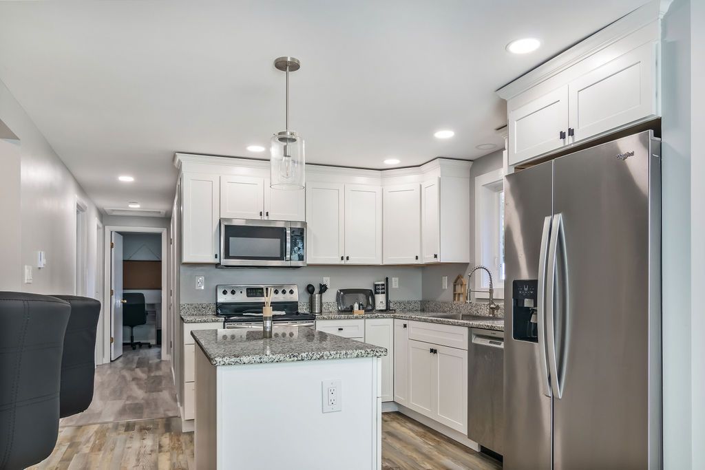 Modern kitchen with white cabinets and stainless steel appliances in Mystic, CT.