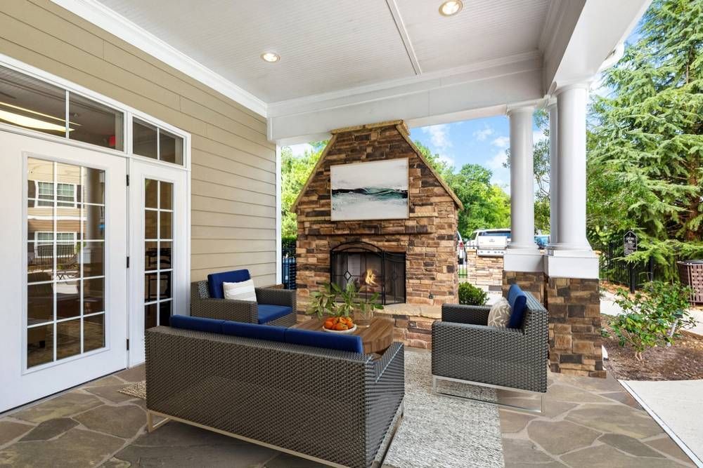 Patio with a fireplace and a couch and chairs.