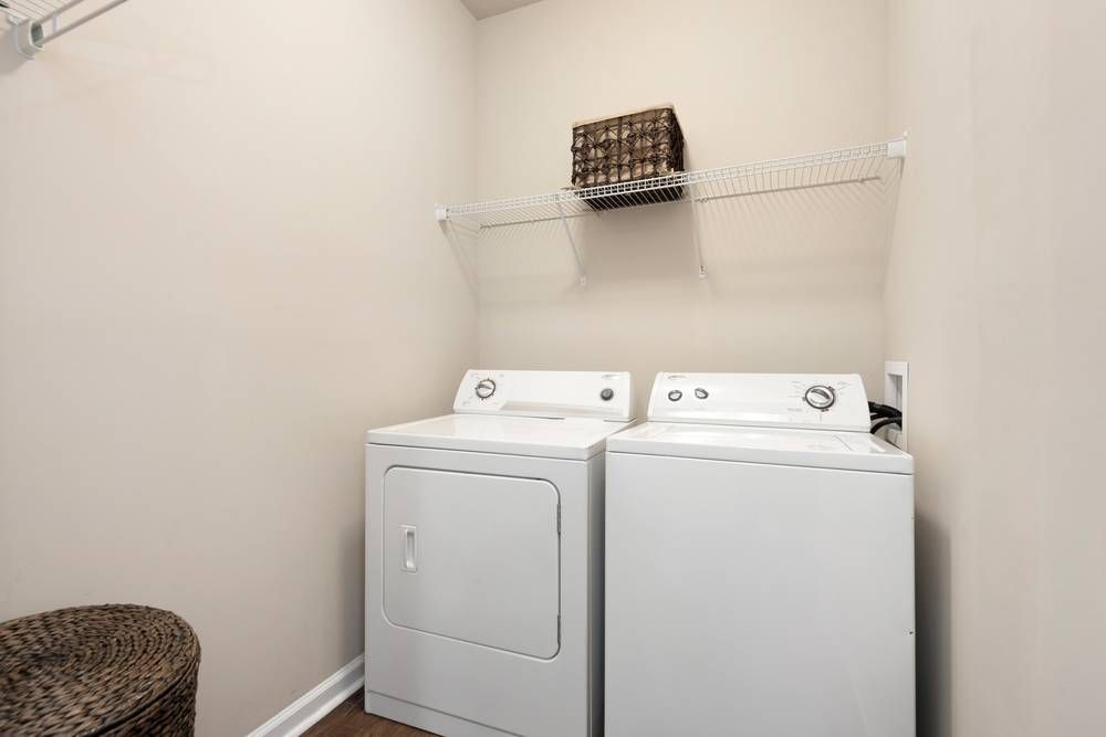 Laundry room with a washer and dryer and a chair.