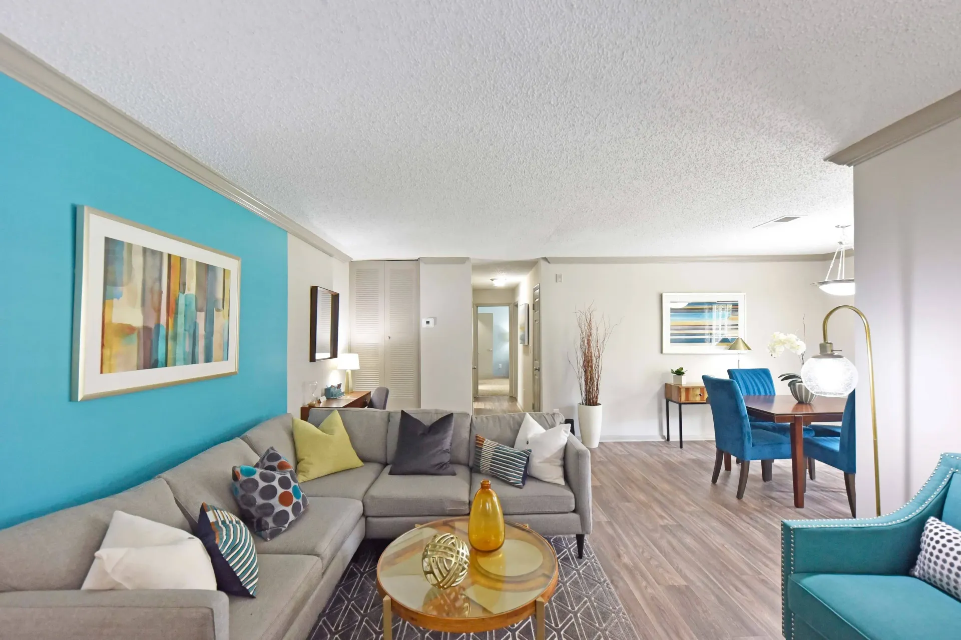 A modern West Knoxville, TN apartment fully furnished  living room with a couch , chair , table , and blue wall.