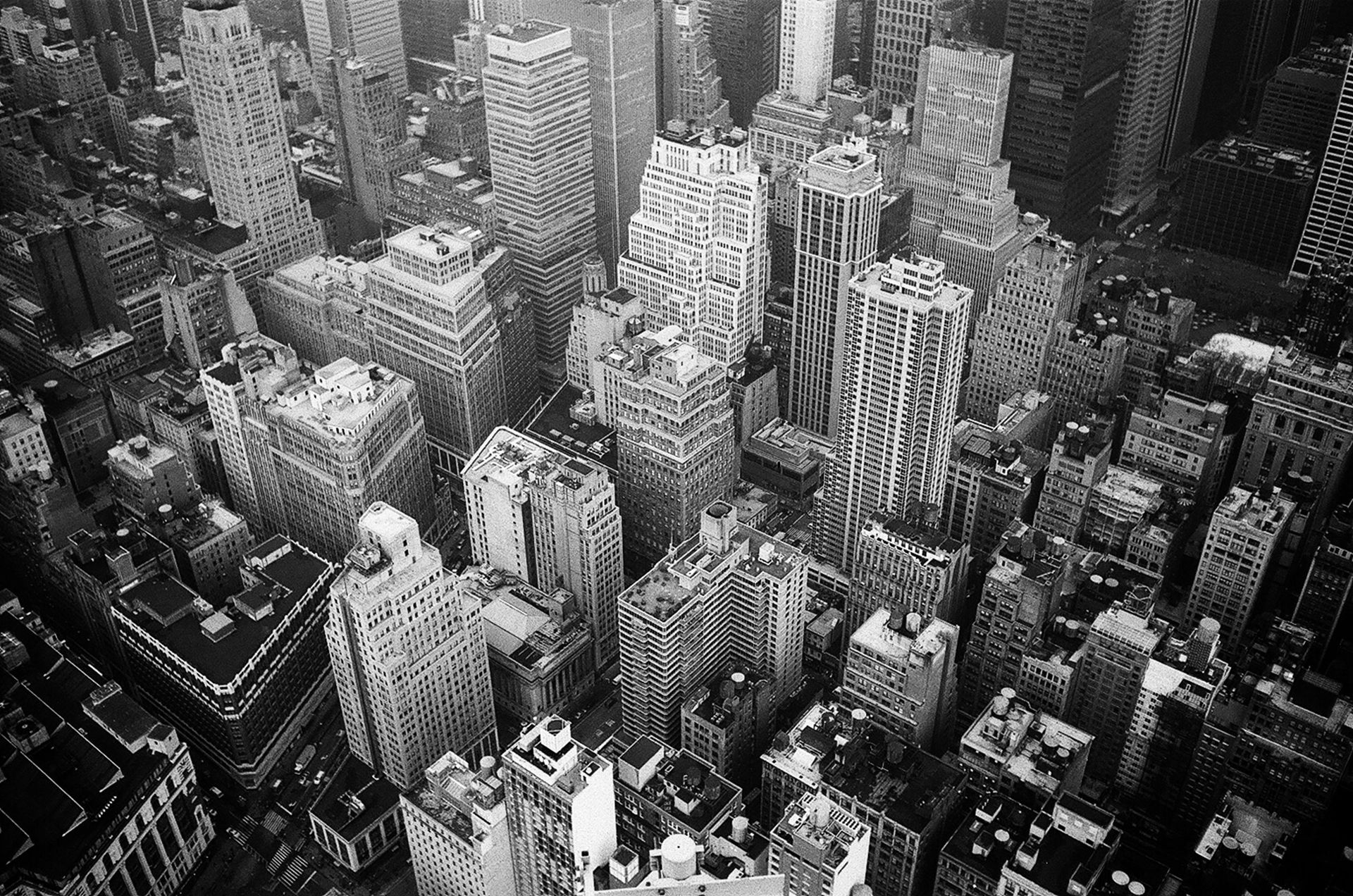 An aerial view of a city with lots of buildings in black and white.