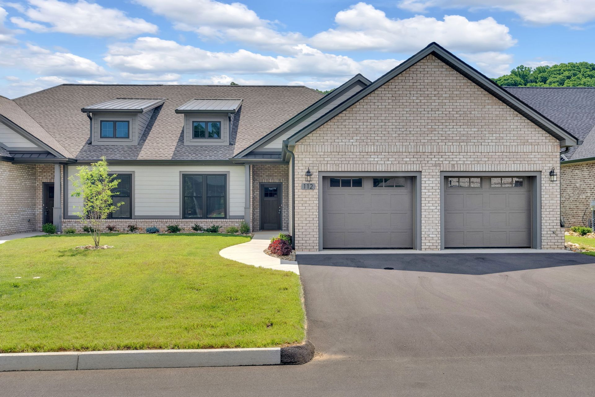 A large brick house with two garage doors.