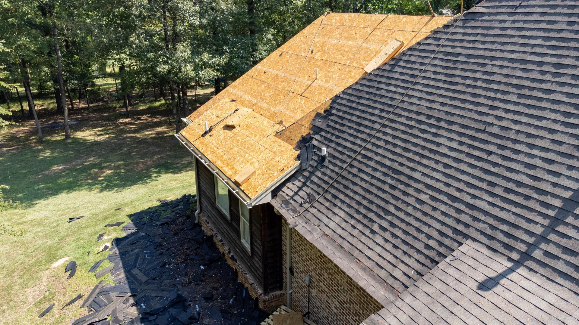 Partial roof replacement with new decking installed and shingles in progress.