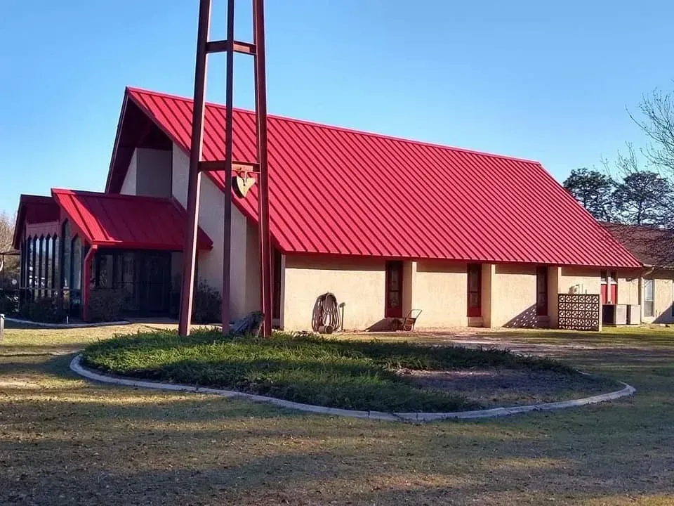 A church with a red roof and a cross on top