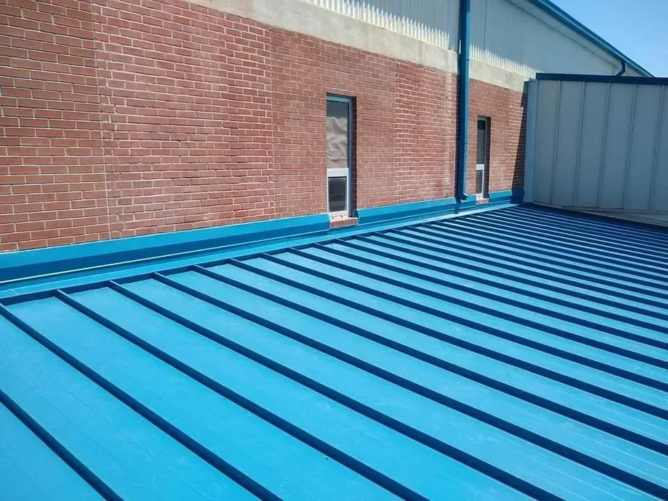 A blue roof with a brick building in the background