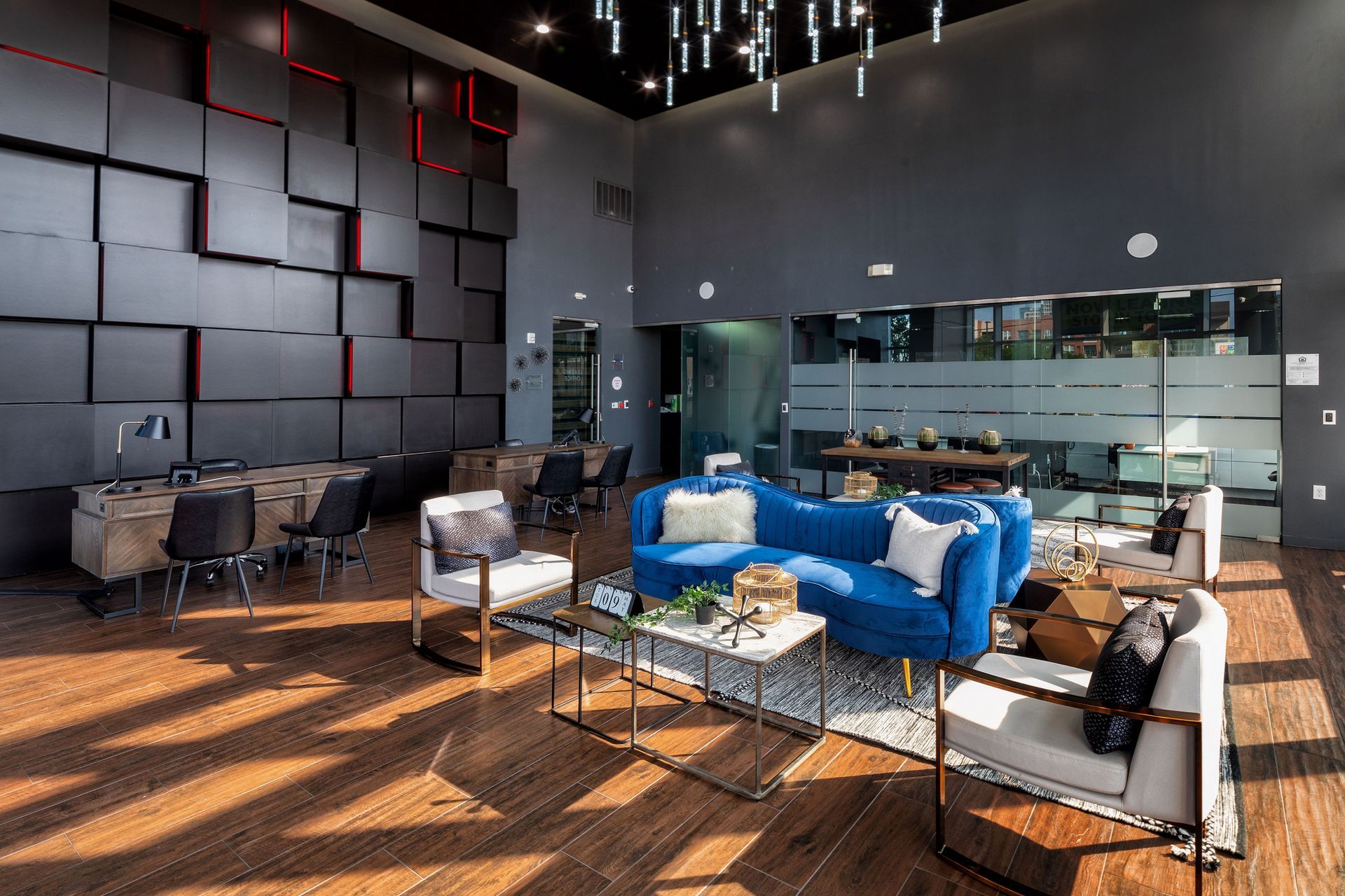 A living room with a blue couch , chairs , and tables.