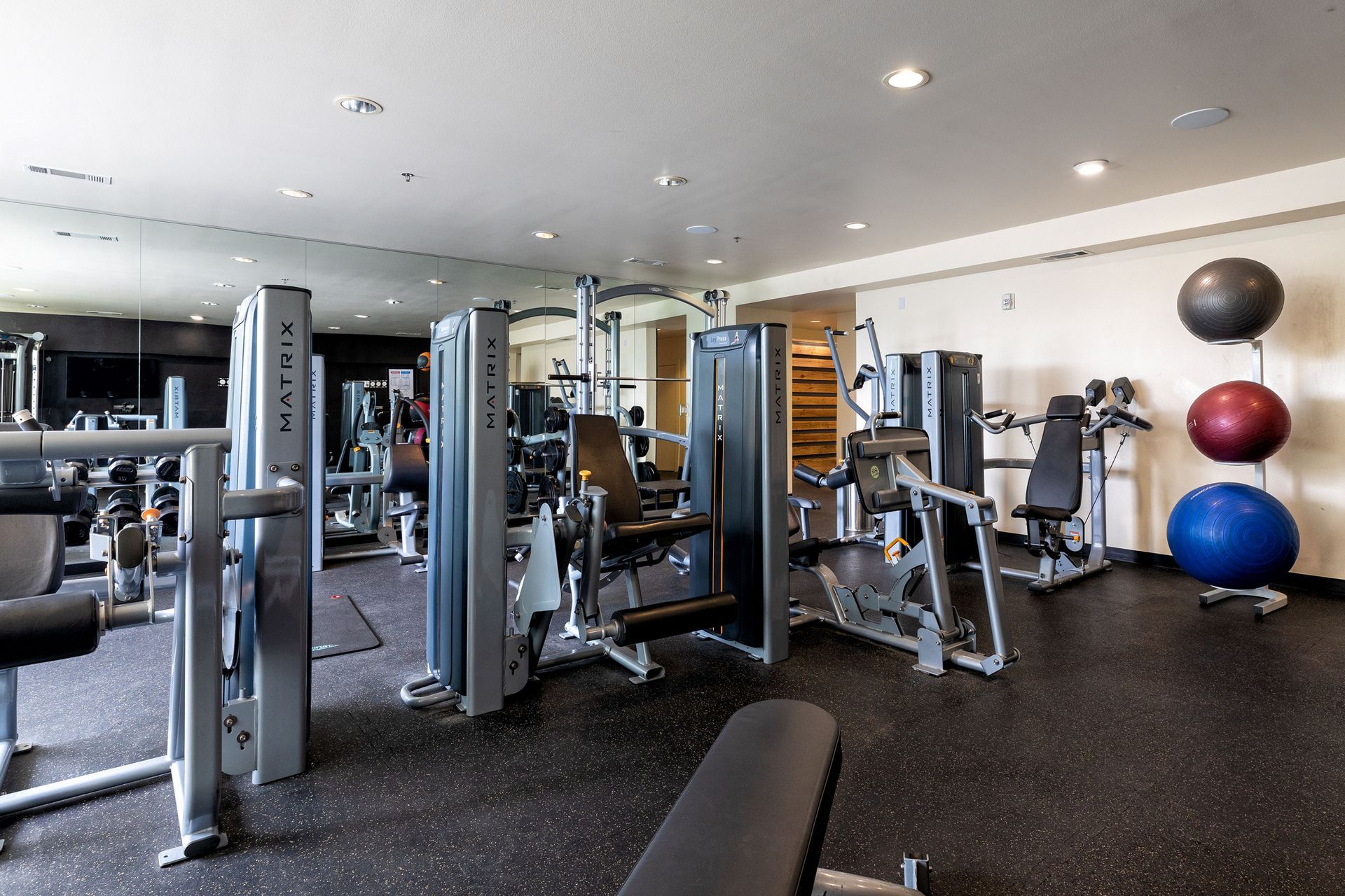 A large gym filled with lots of exercise equipment.