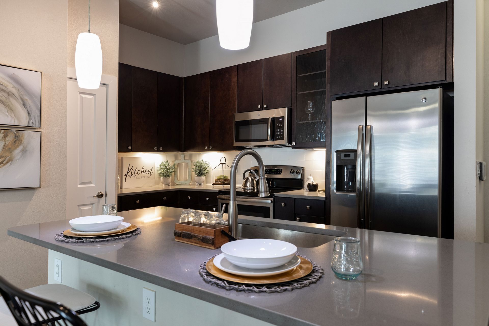 A kitchen with stainless steel appliances and a stainless steel refrigerator.