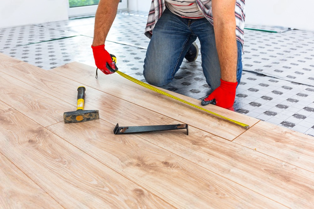 A man is plastering a wall in a room.