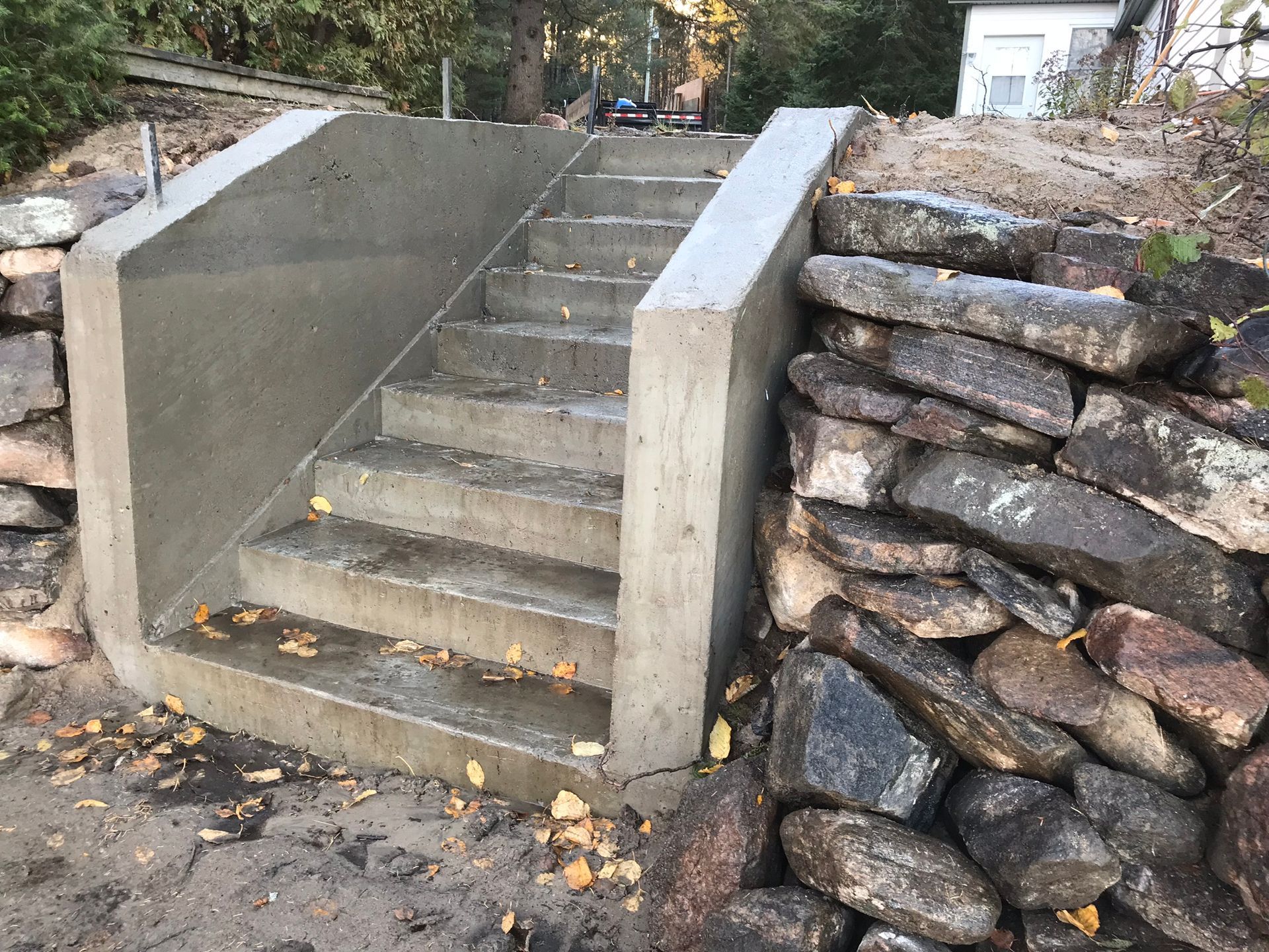 a set of concrete stairs leading up to a stone wall .