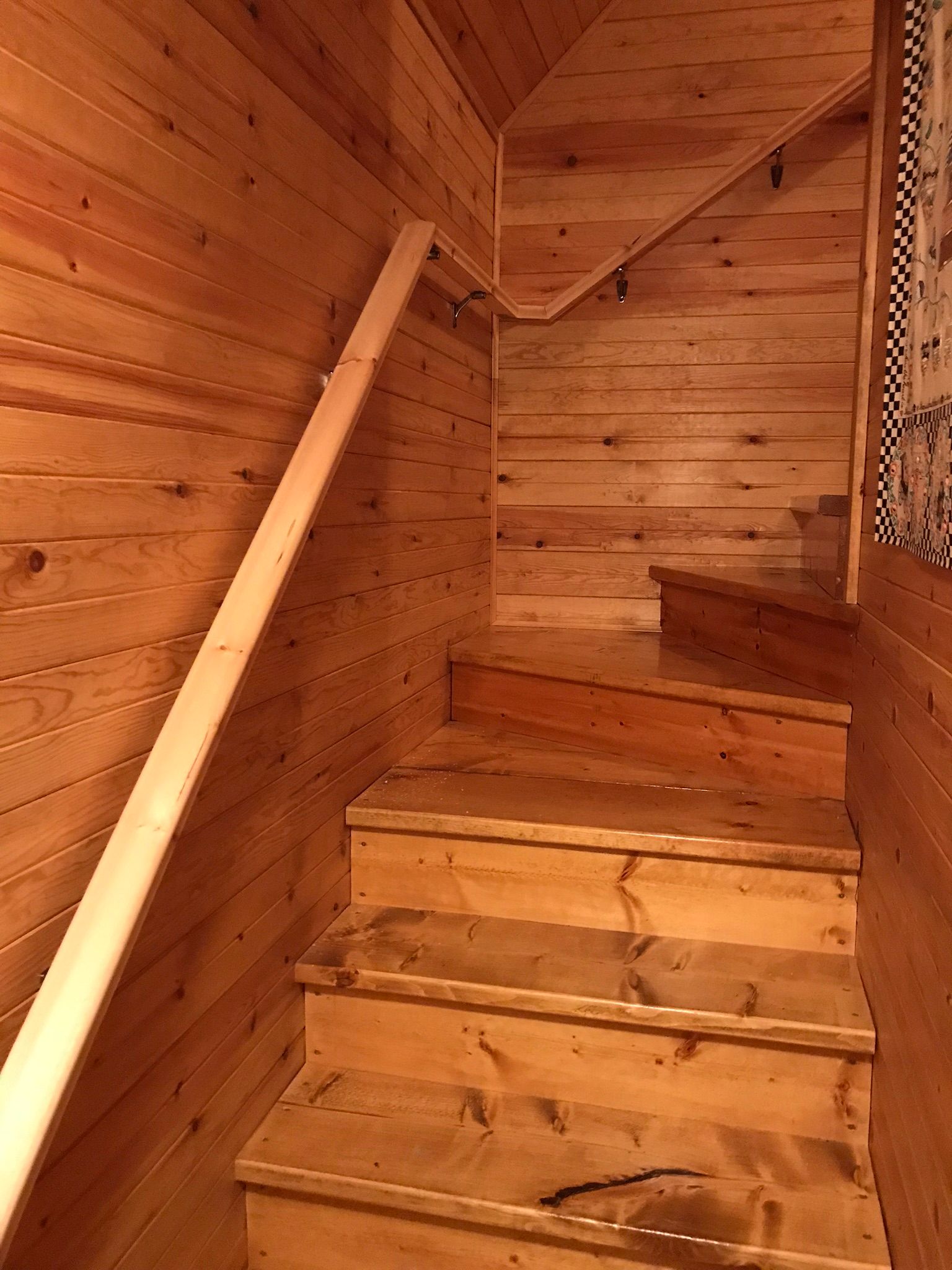 the stairs are made of wood and have a wooden railing .