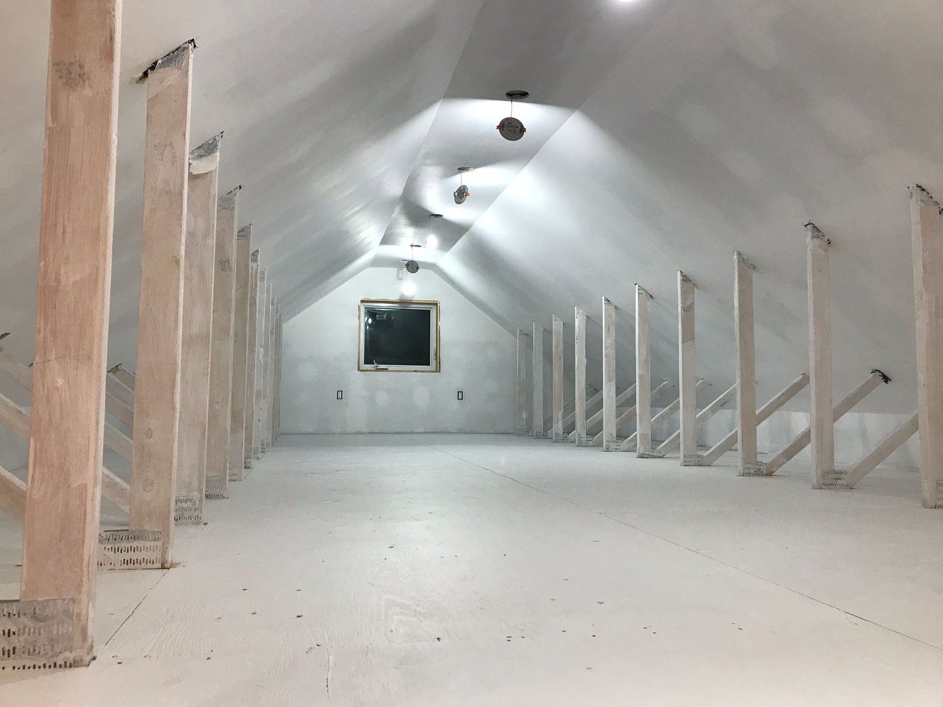 an empty attic with wooden beams and a blackboard on the wall .