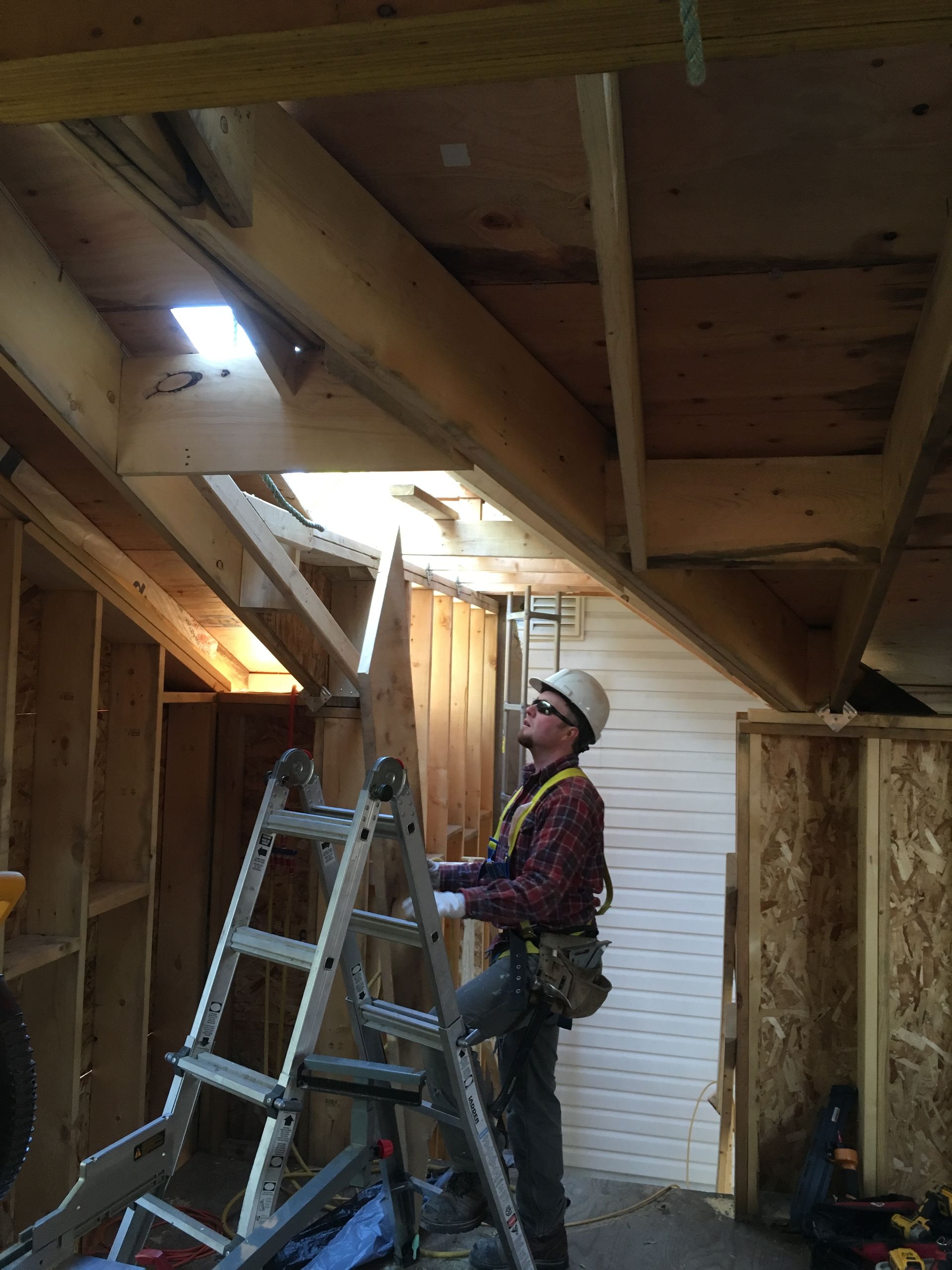 a man is standing on a ladder in a room .
