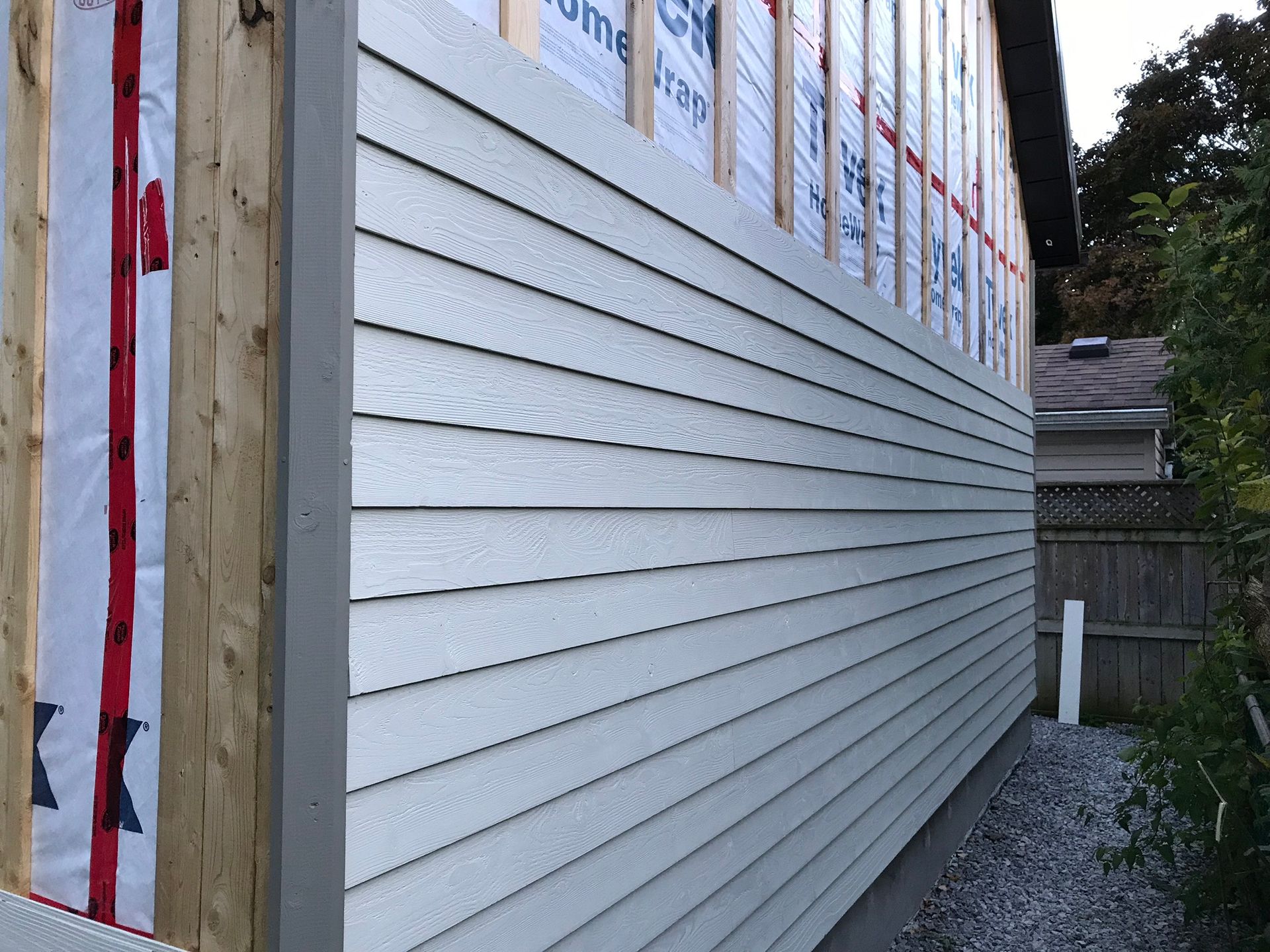 the side of a house with siding being installed