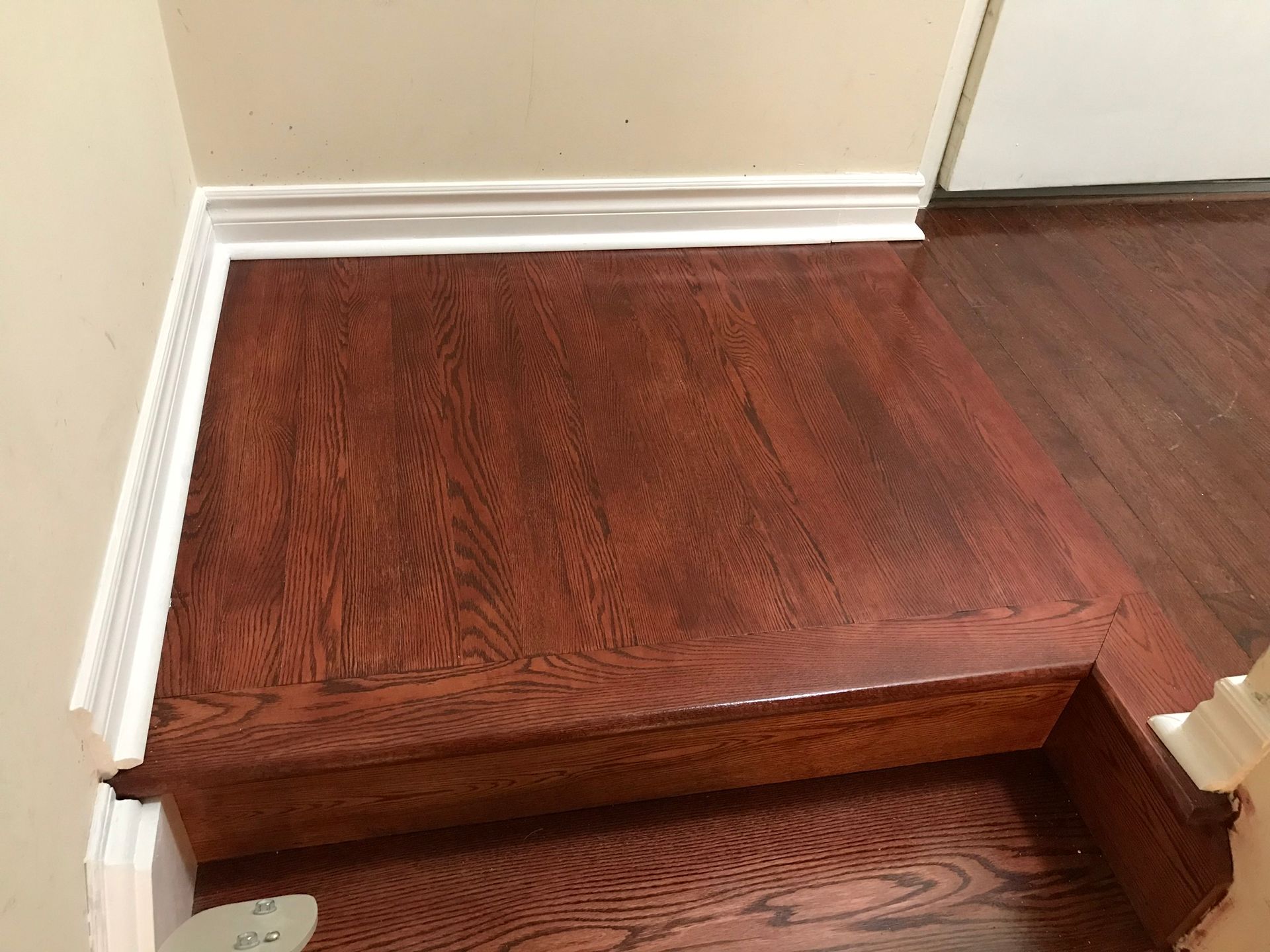 a wooden floor with stairs leading up to it in a room .