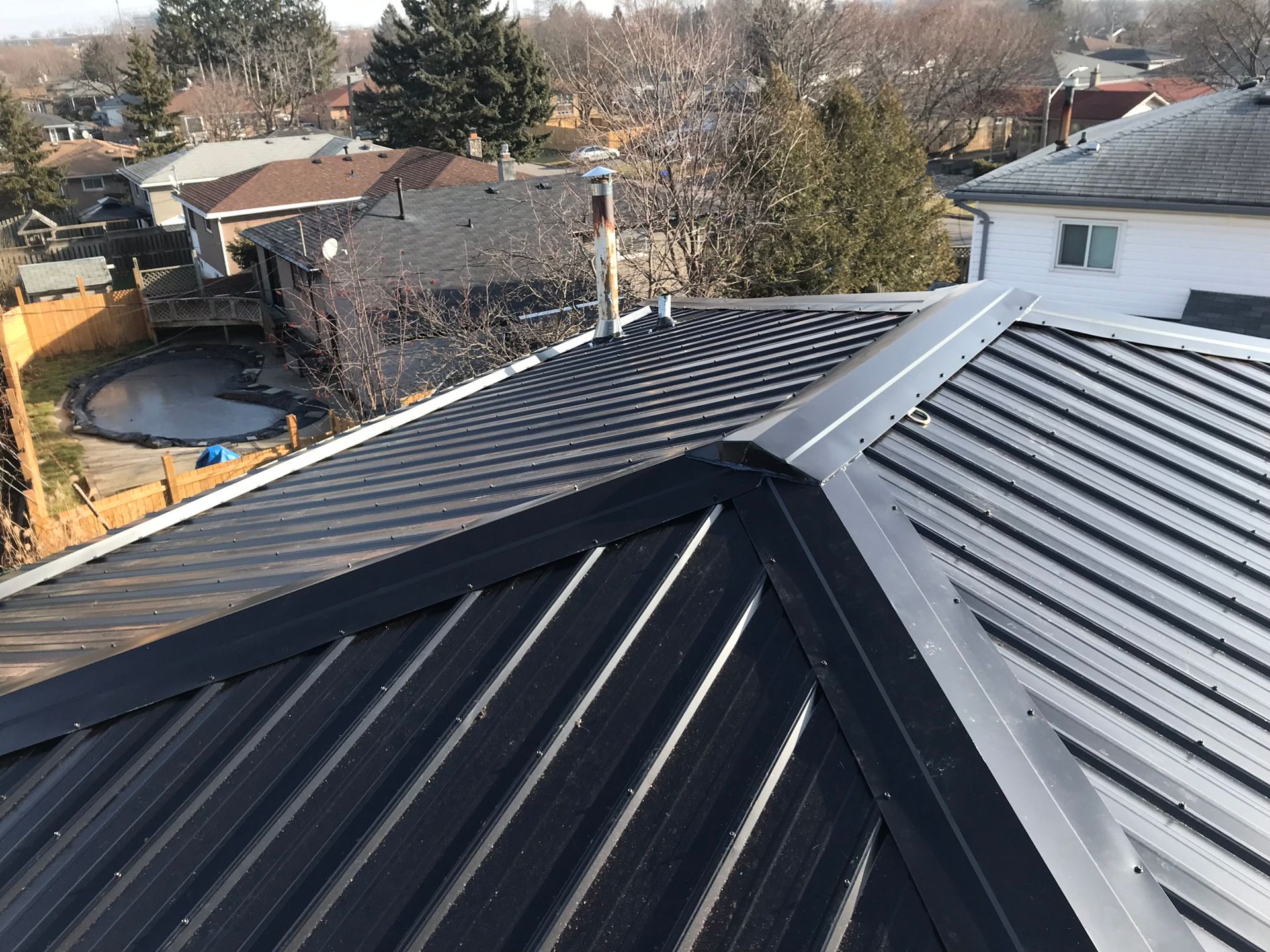 the roof of a house with a metal roof and a pool in the backyard .