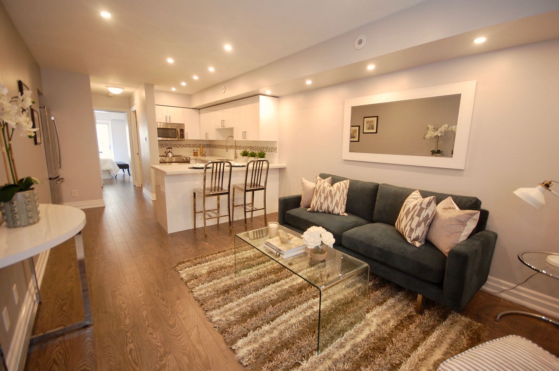 a living room with a couch , coffee table , chairs and a rug .