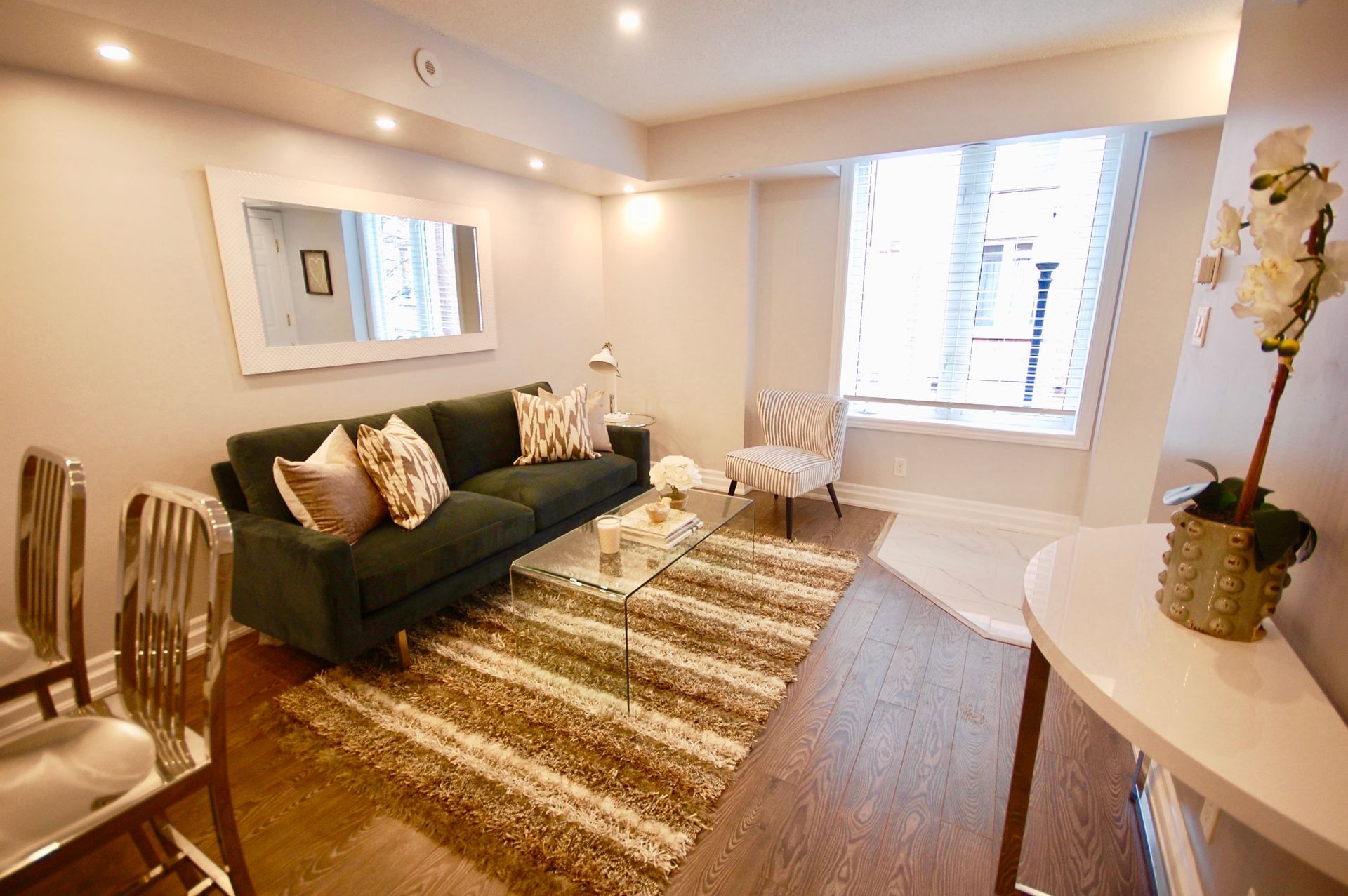 a living room with a couch , chair , table and rug .
