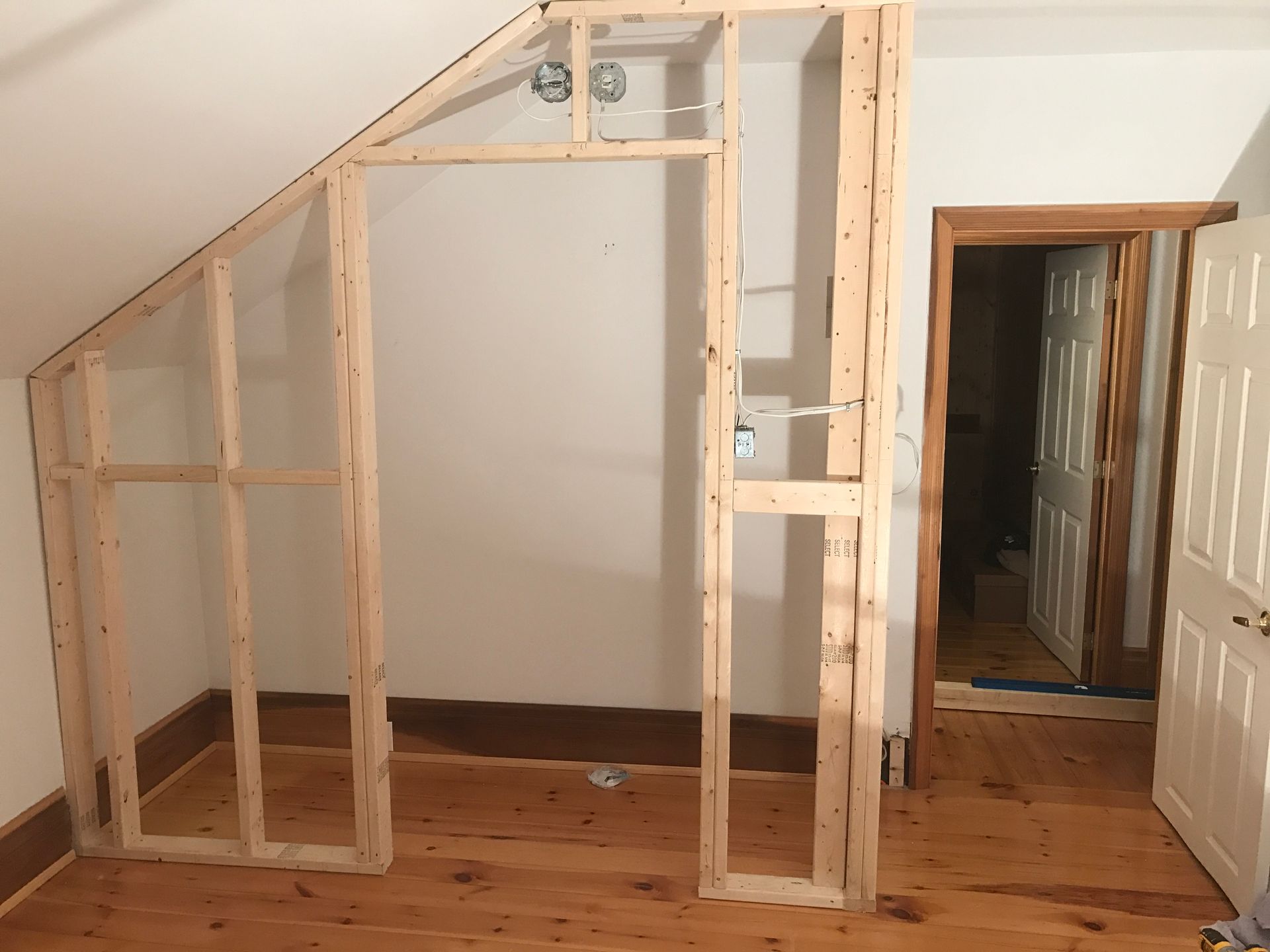 a wooden frame is being built in a room with a slanted ceiling .