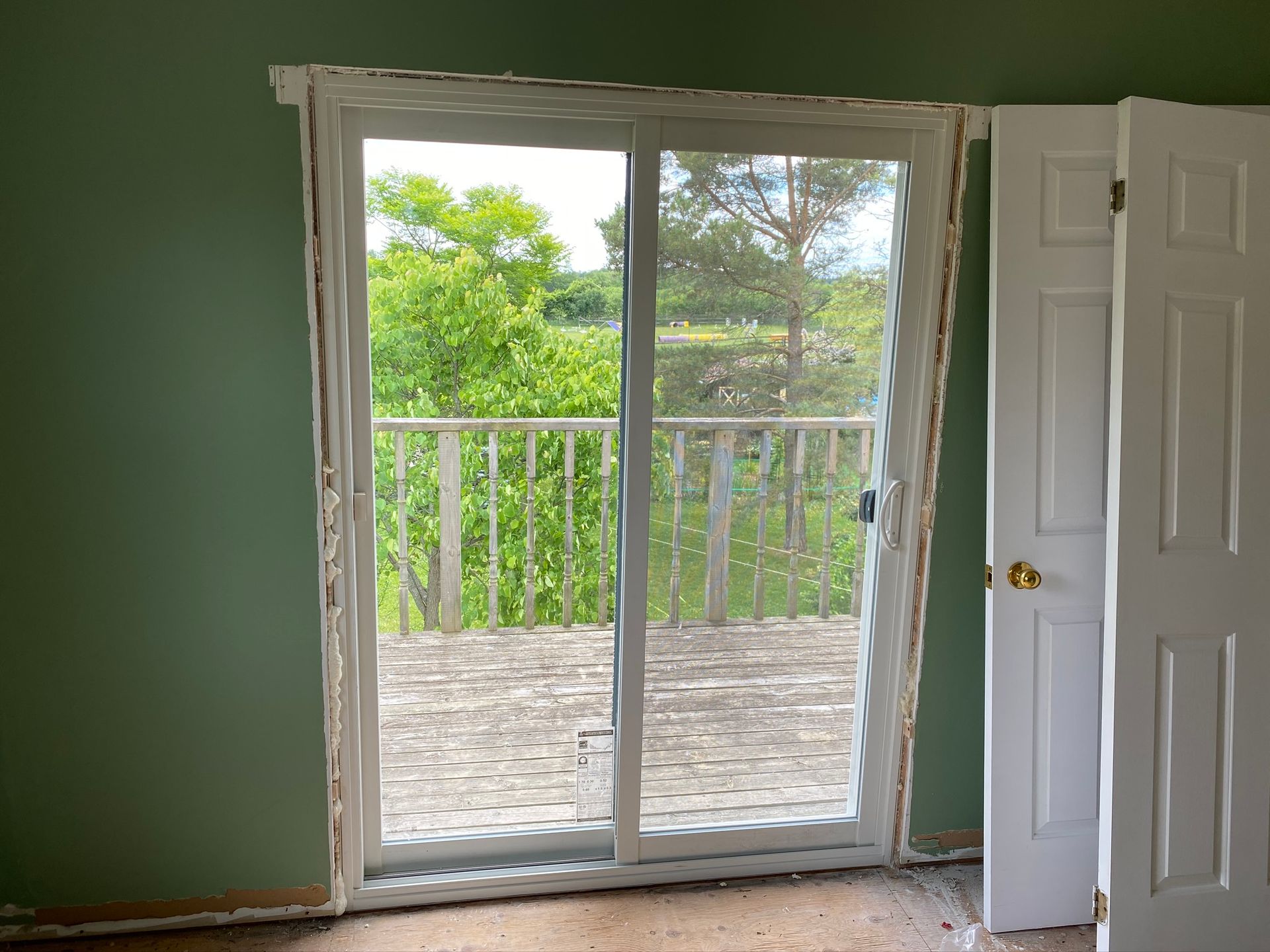 an empty room with a sliding glass door leading to a balcony .