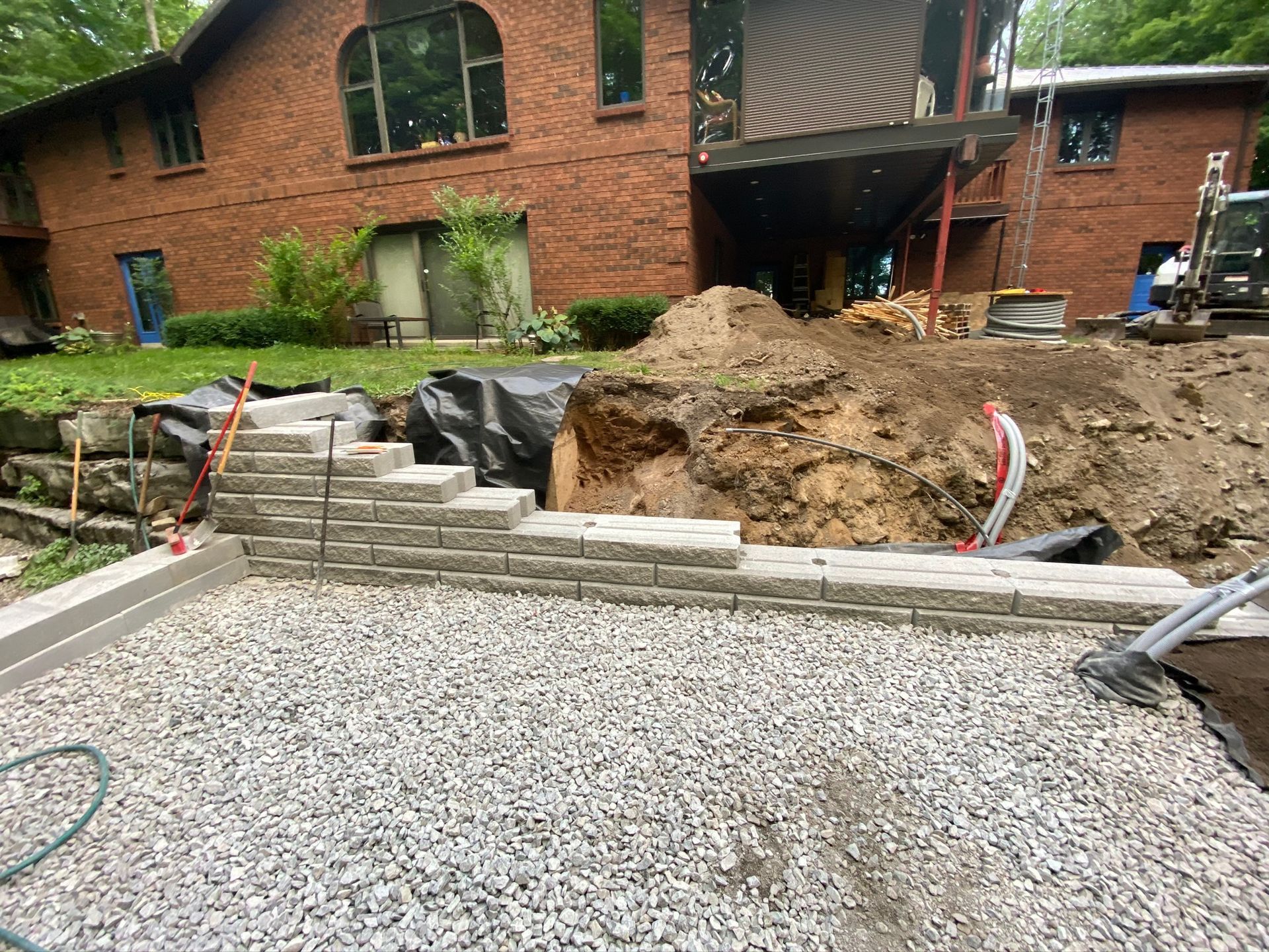 a brick house is being built with gravel in front of it .