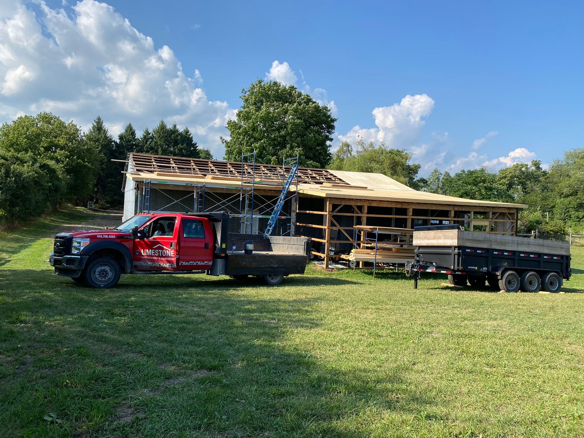 a red truck is parked in front of a house under construction .