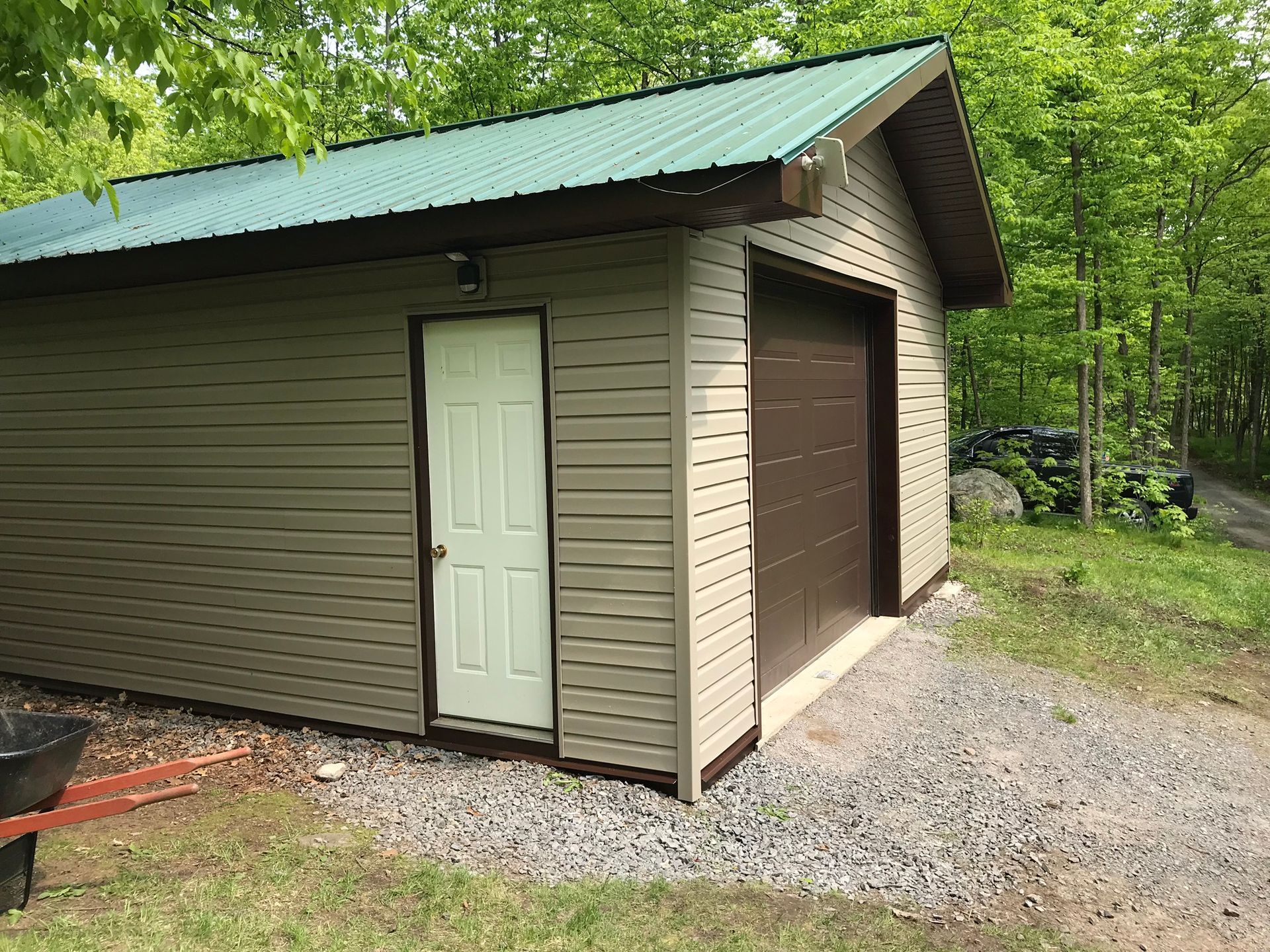 a garage with a green roof and a brown garage door