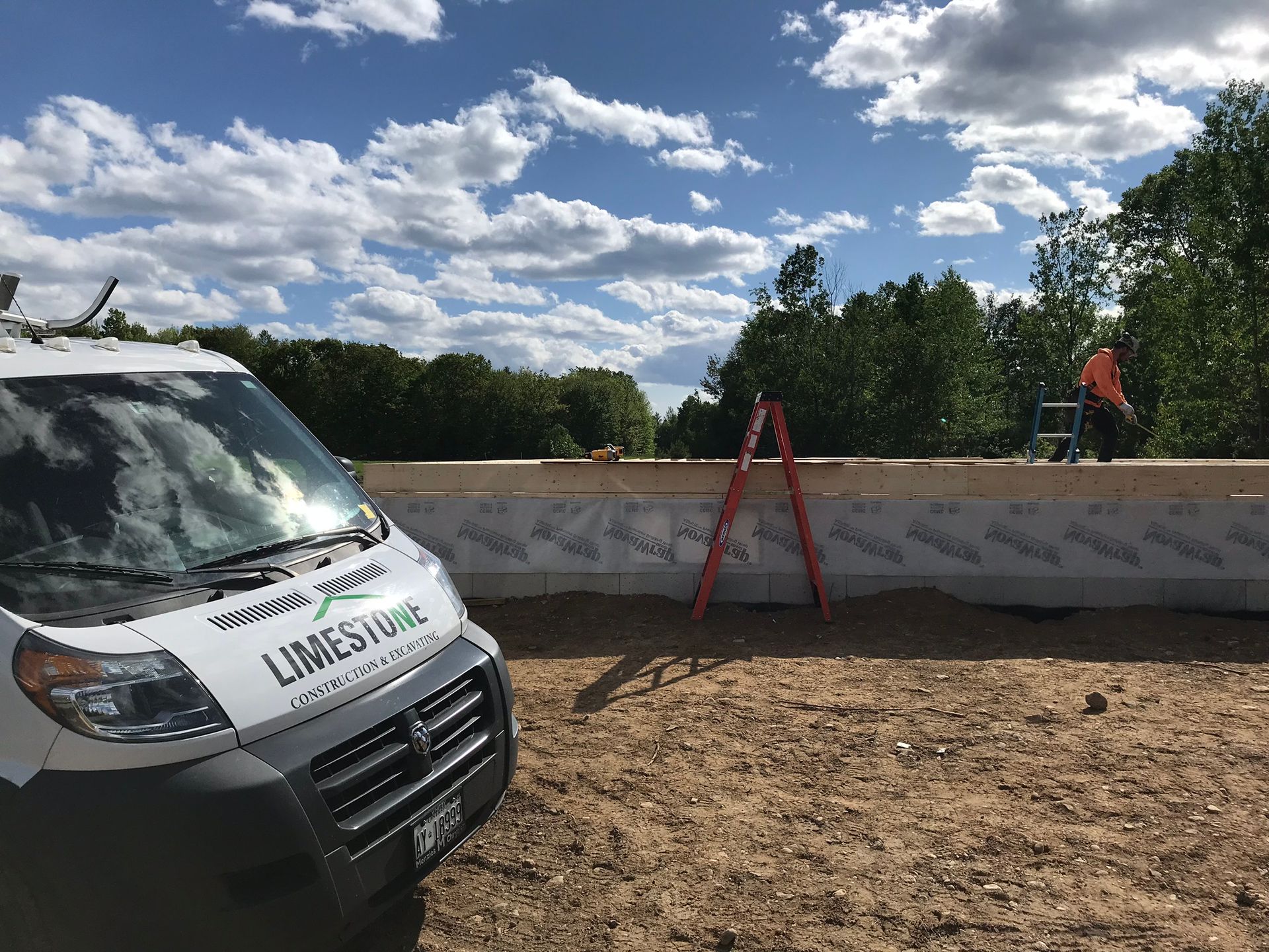 a white van with limestone written on the side is parked in a dirt field .