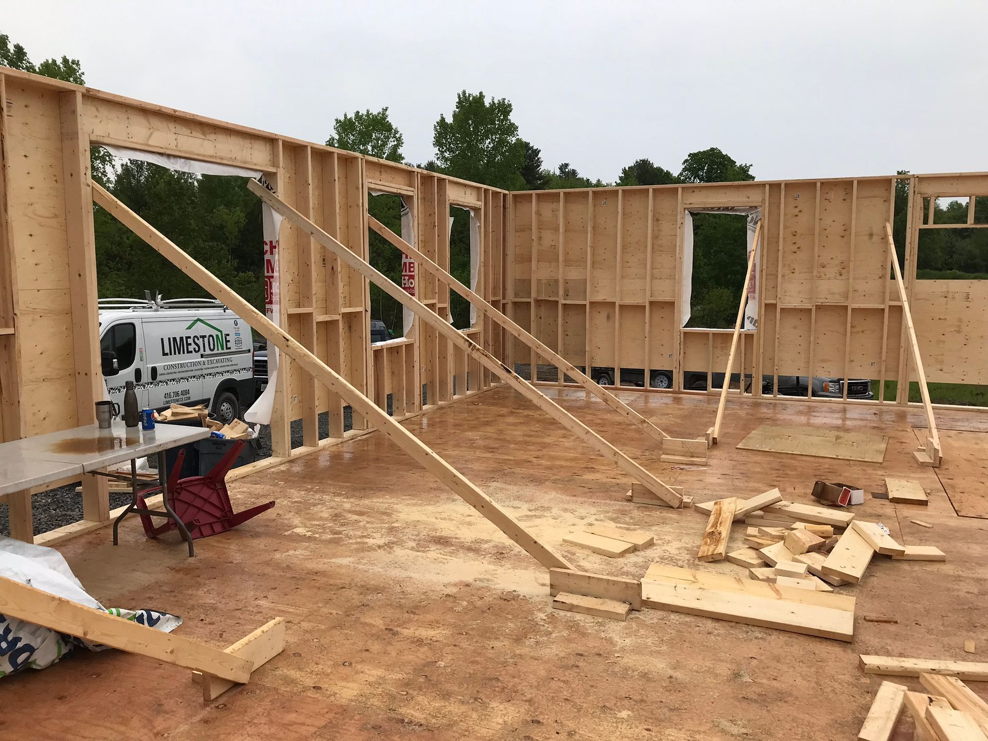 a wooden house is being built on a dirt ground .