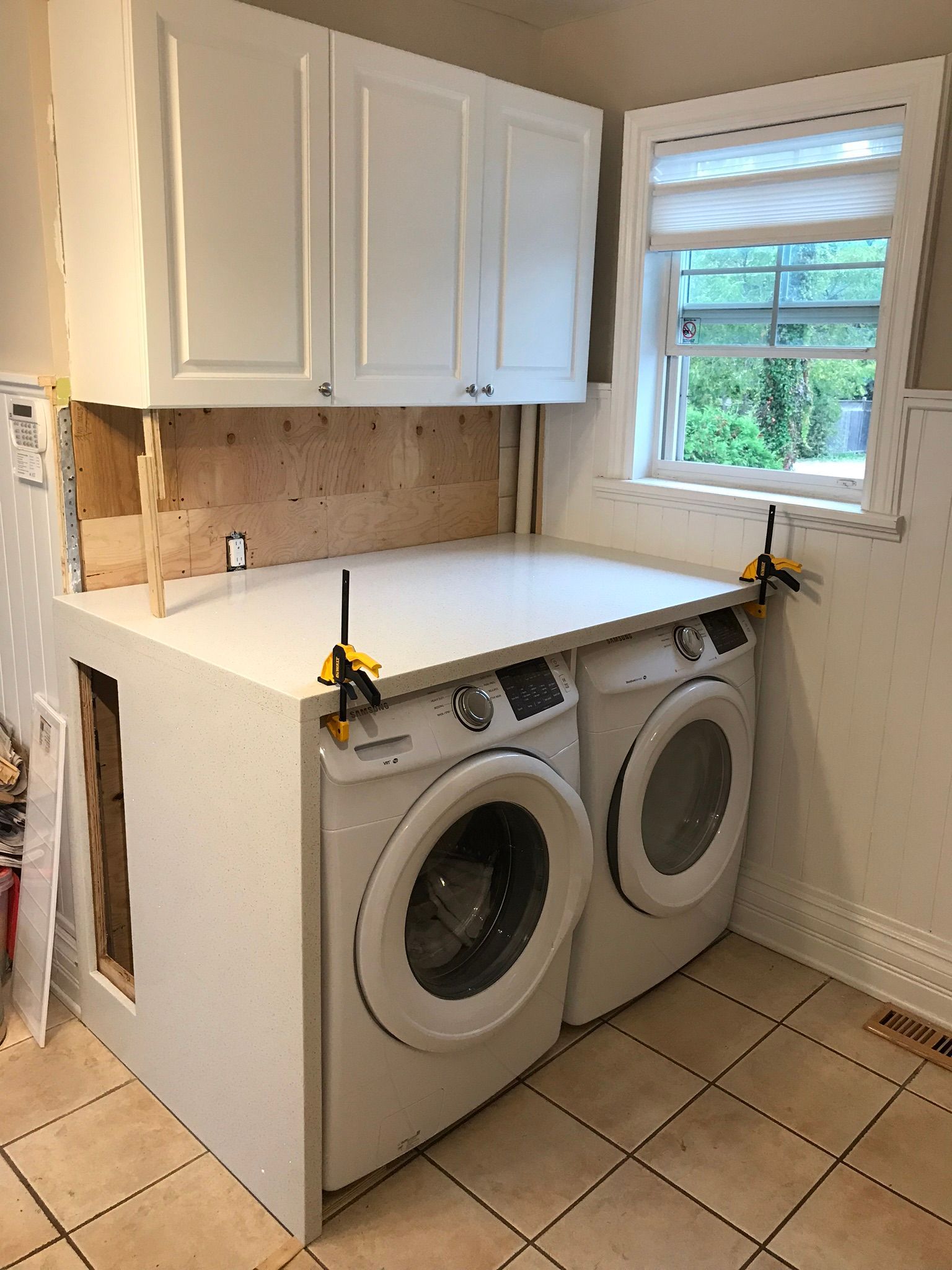 a laundry room with a washer and dryer and a window .