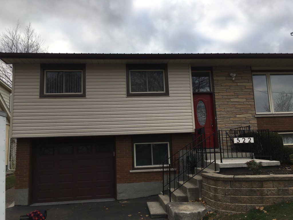 the front of a house with a red door and stairs