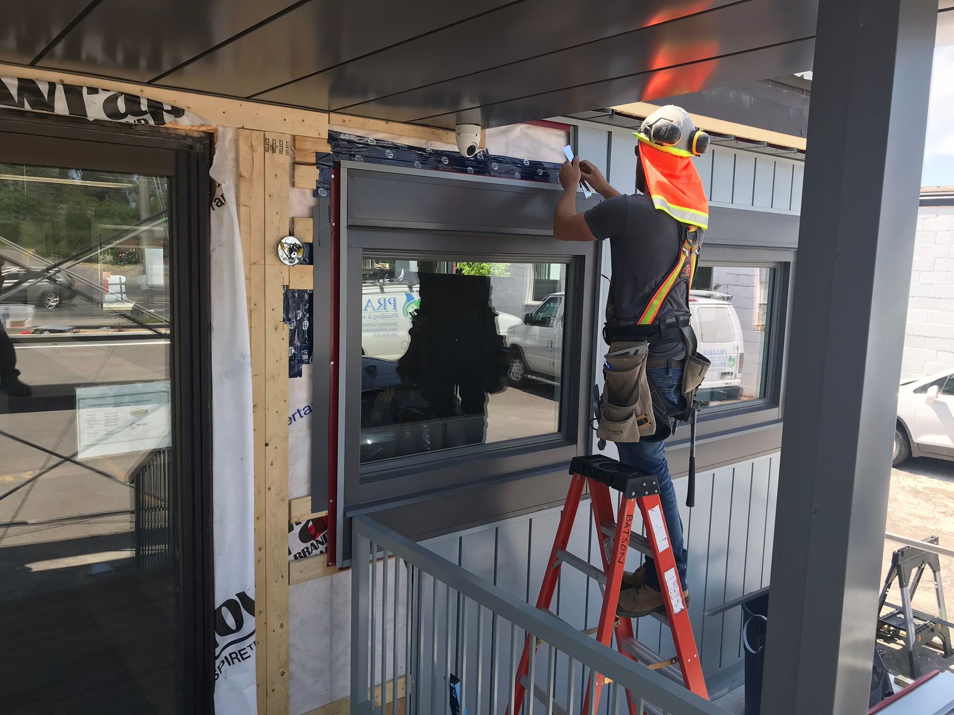a man is standing on a ladder working on a window .