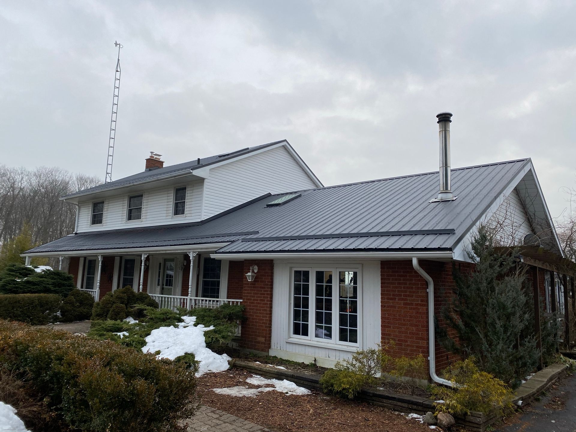 a large house with a metal roof and a chimney