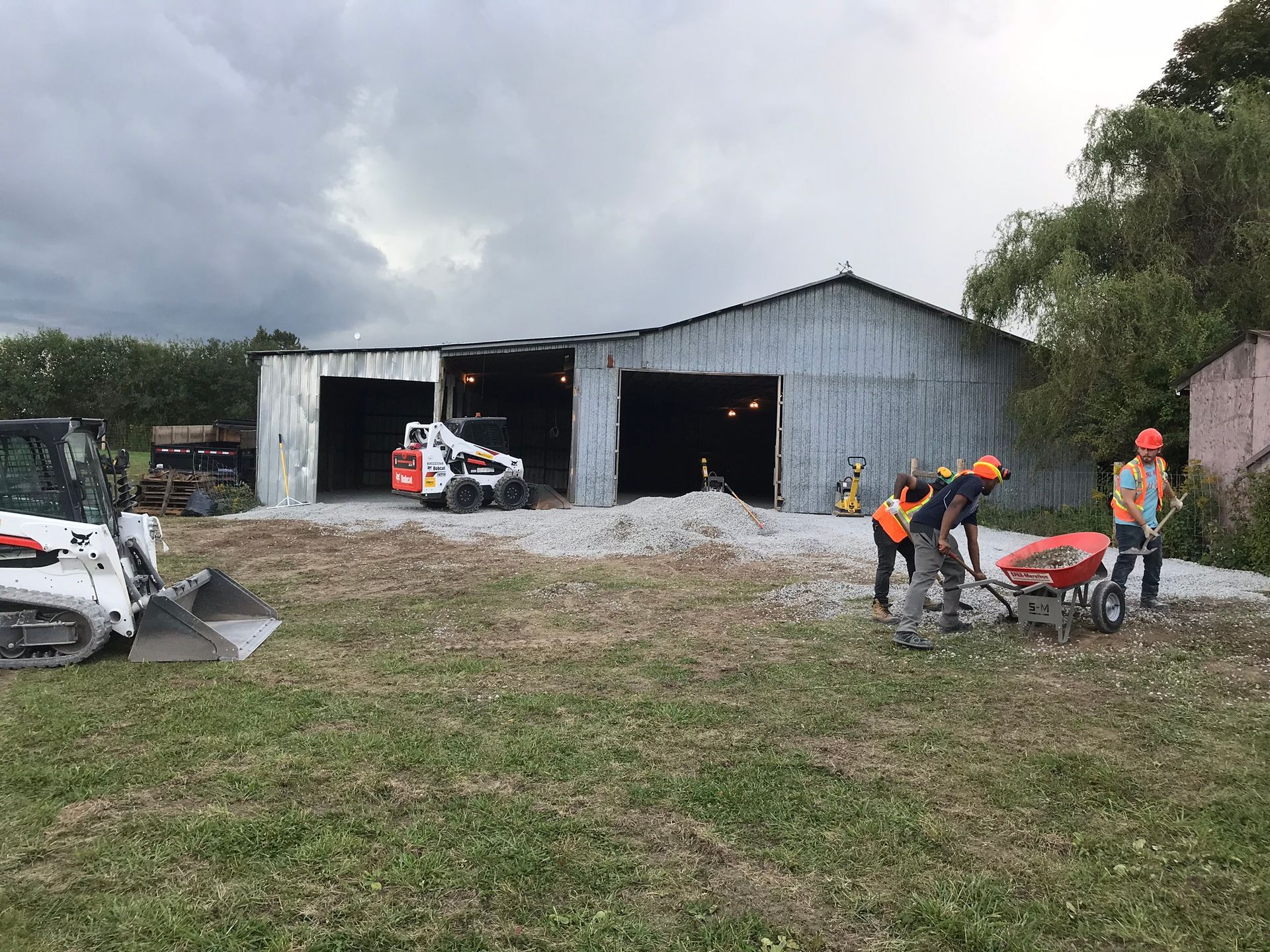 a group of construction workers are working in a field in front of a building .