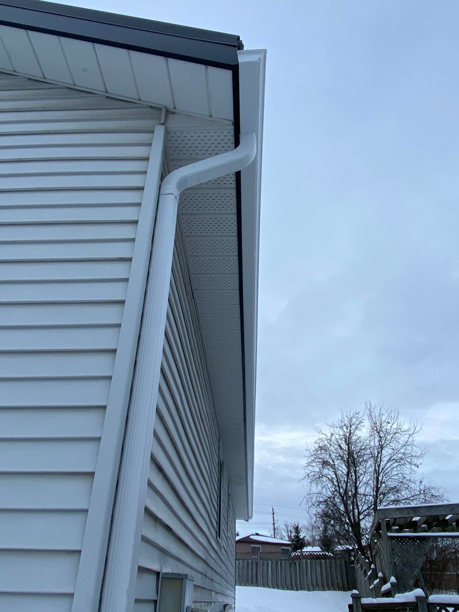 a white house with a gutter on the side of it .