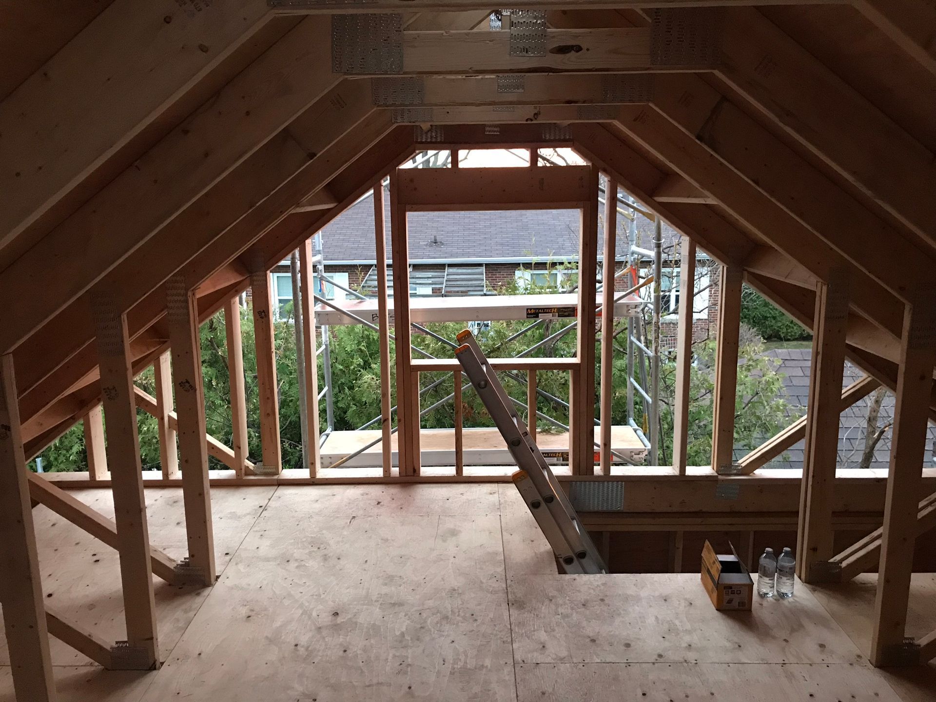 a ladder is in the attic of a house under construction