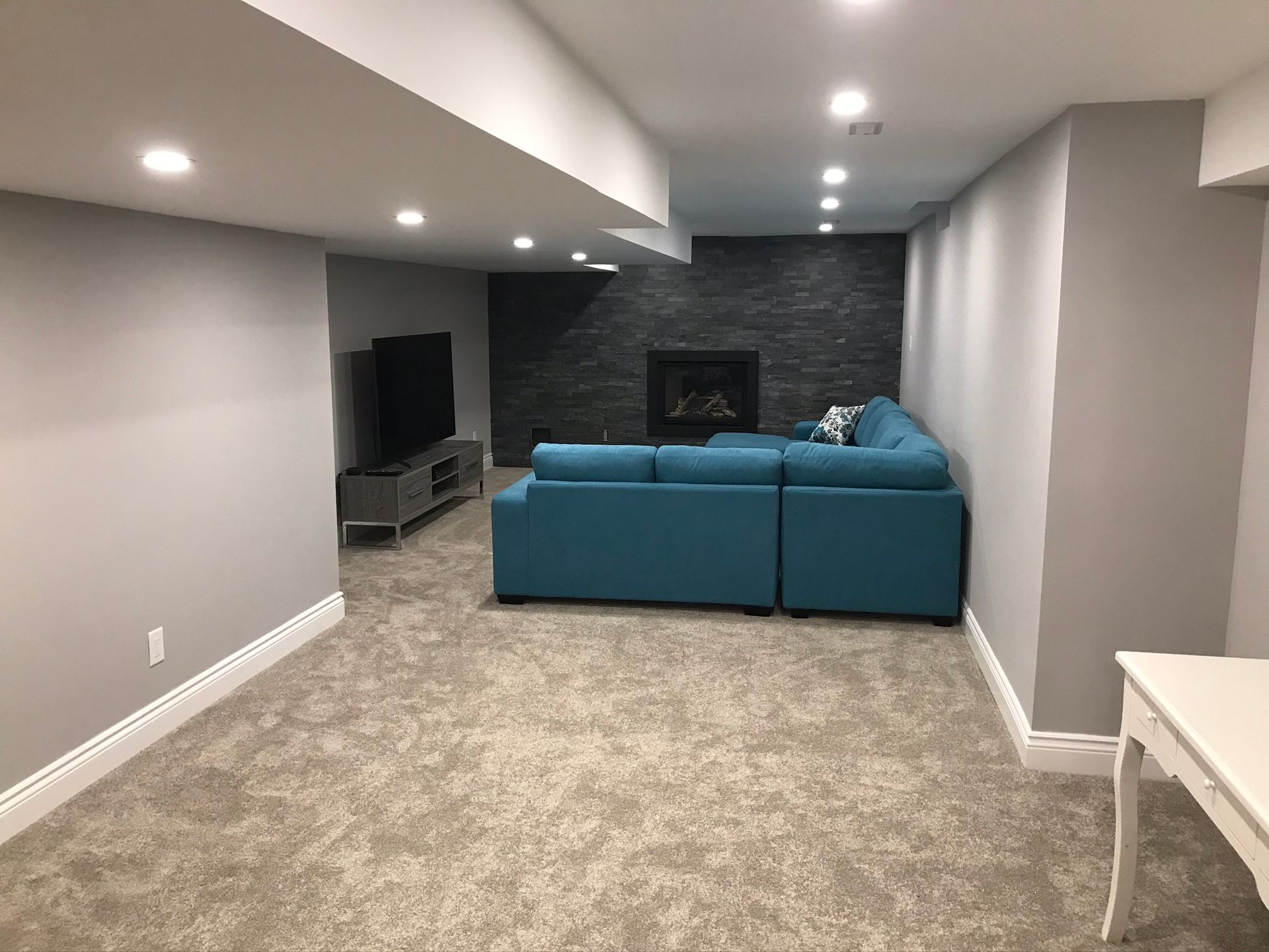 a living room with a blue couch and a fireplace .