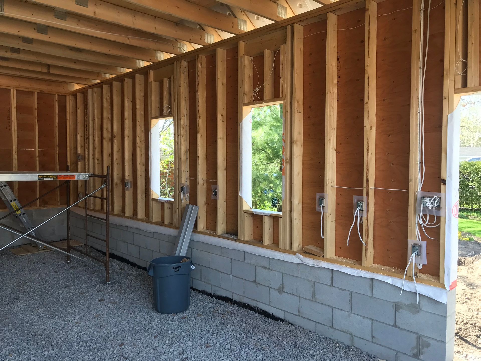 a building under construction with a scaffolding and a trash can .