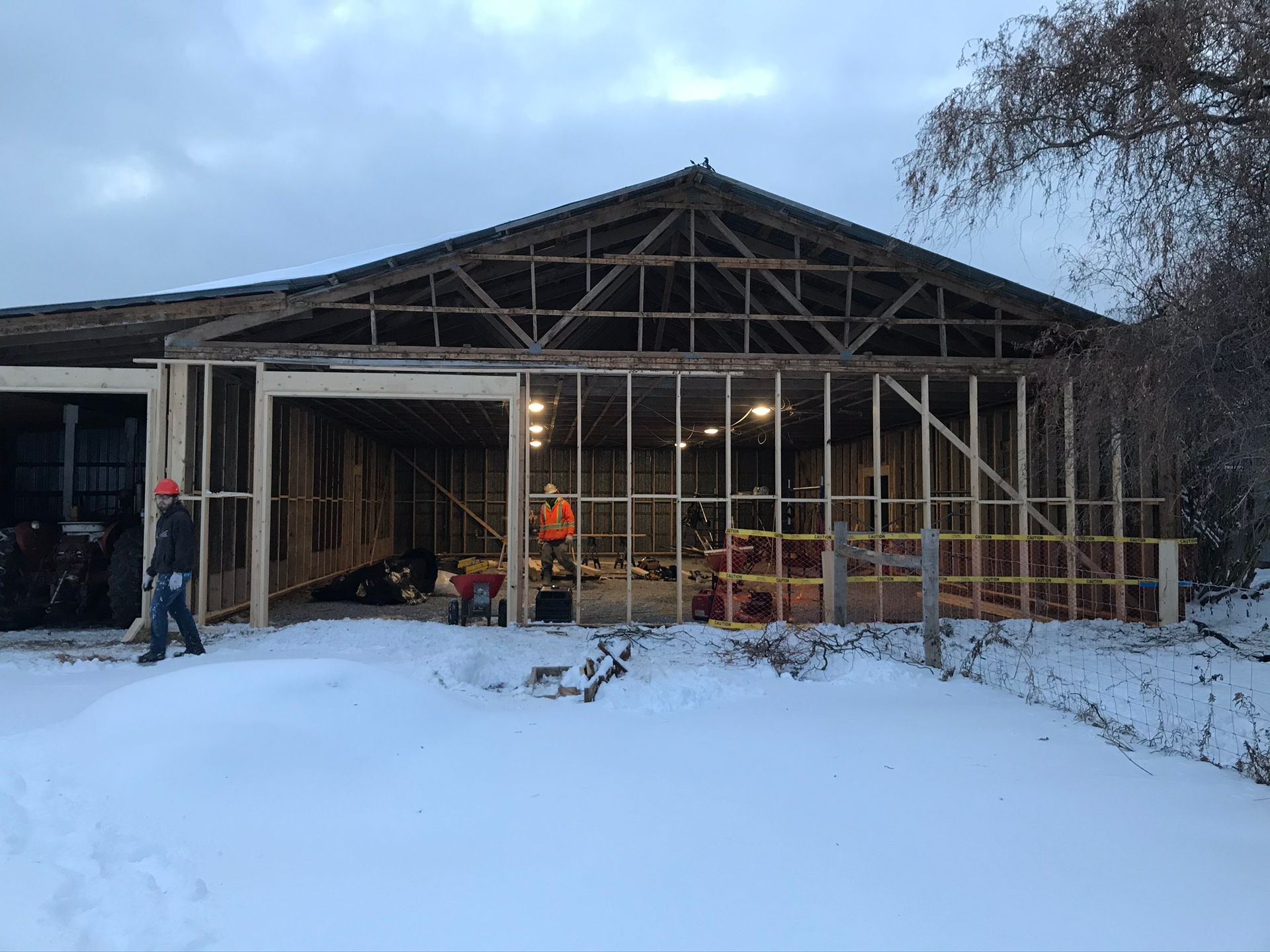 a man is standing in front of a building under construction in the snow .