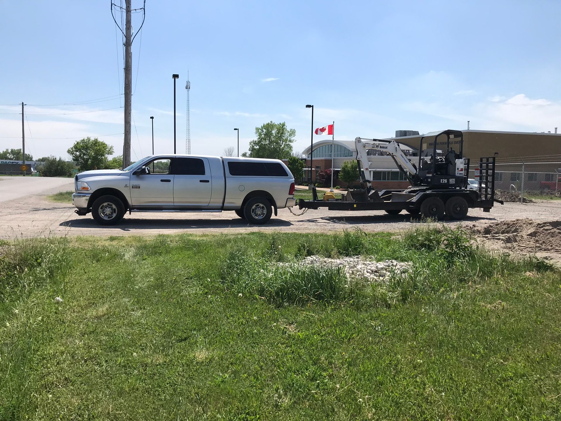 a truck is towing a trailer with a tractor on it .