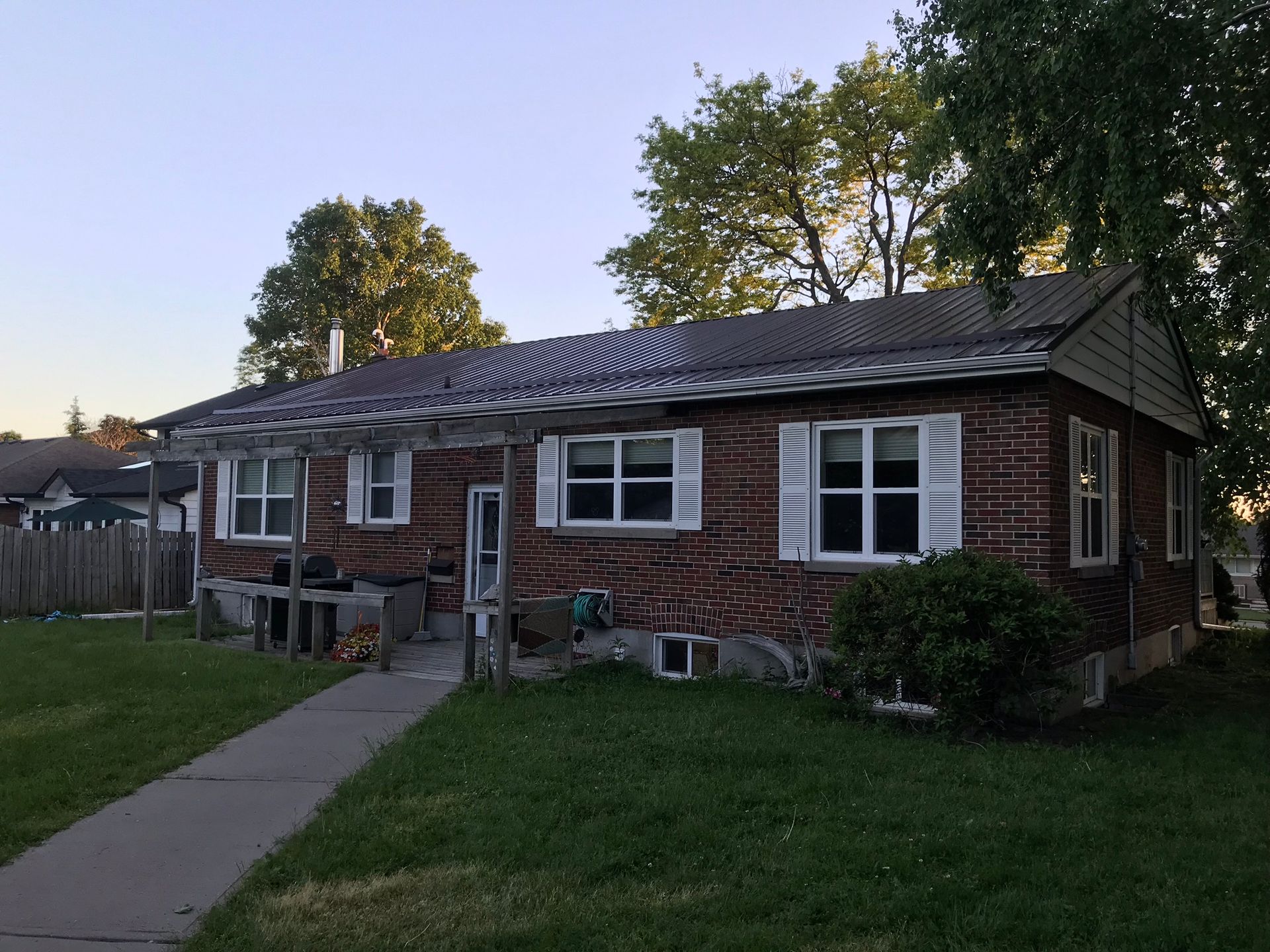 a brick house with white shutters on the windows