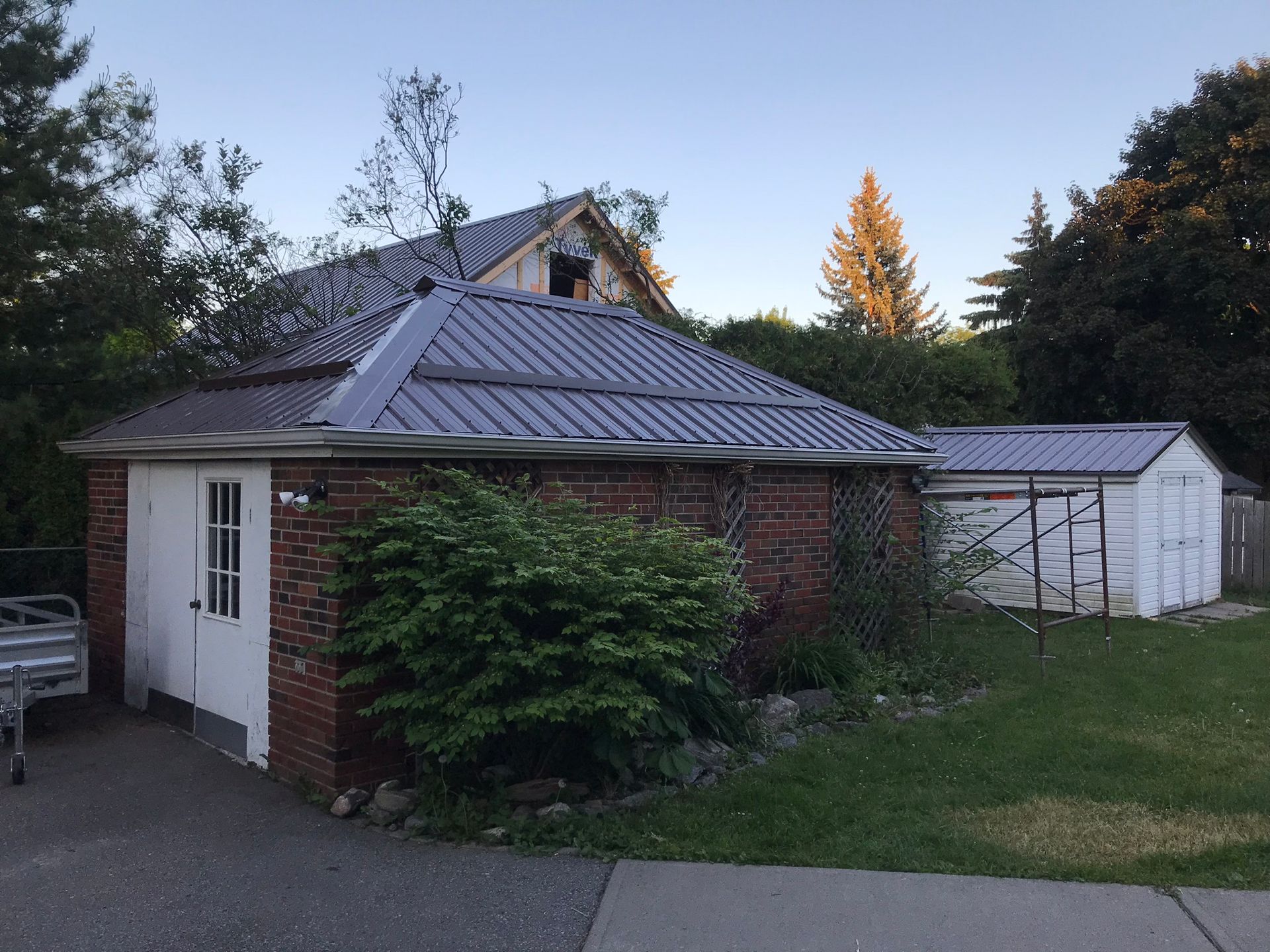 a brick house with a metal roof and a white garage