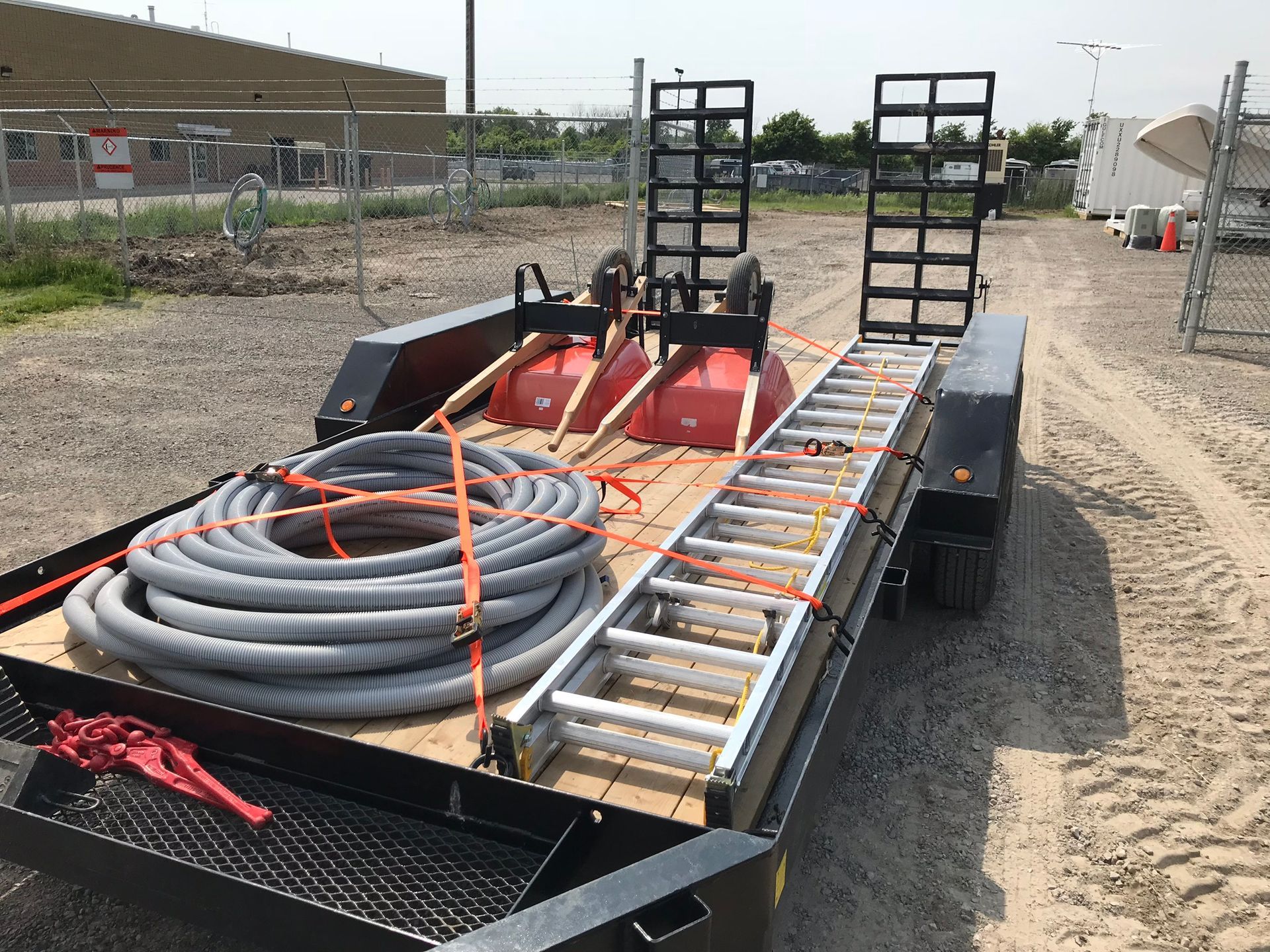 a trailer with a ladder and a hose on it