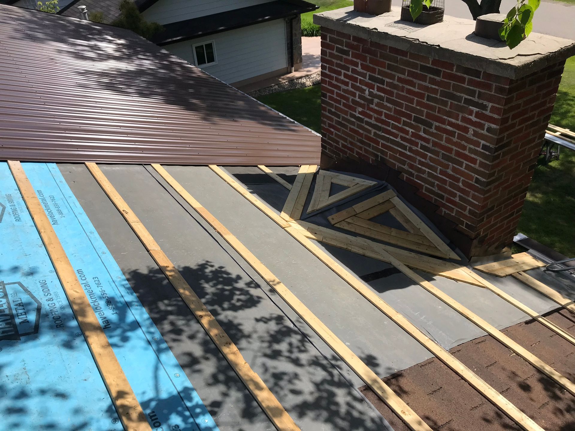 a roof with a brick chimney being built on it