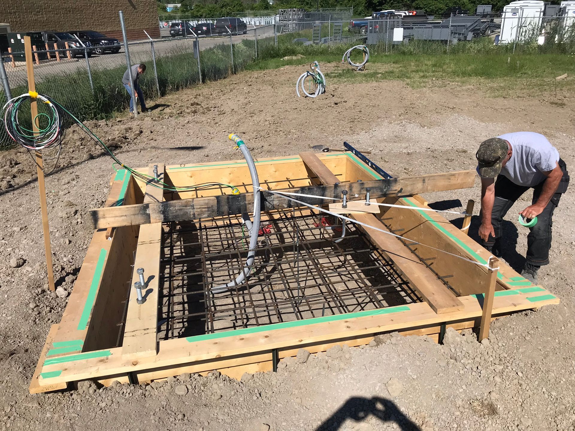 a man is working on a wooden structure in the dirt .