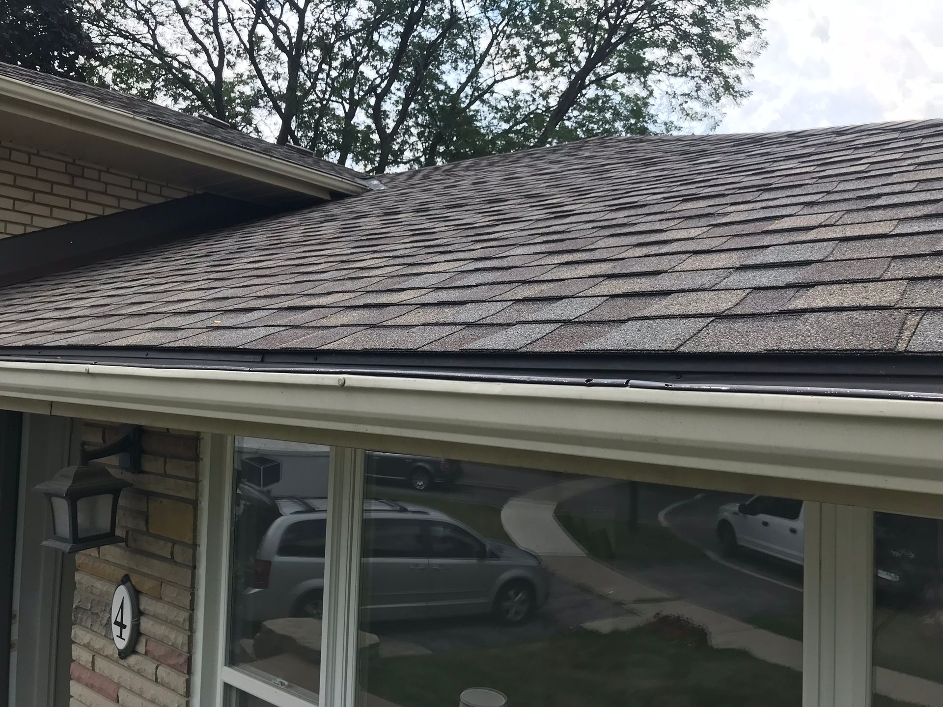 the roof of a house with a gutter and a car parked in front of it .