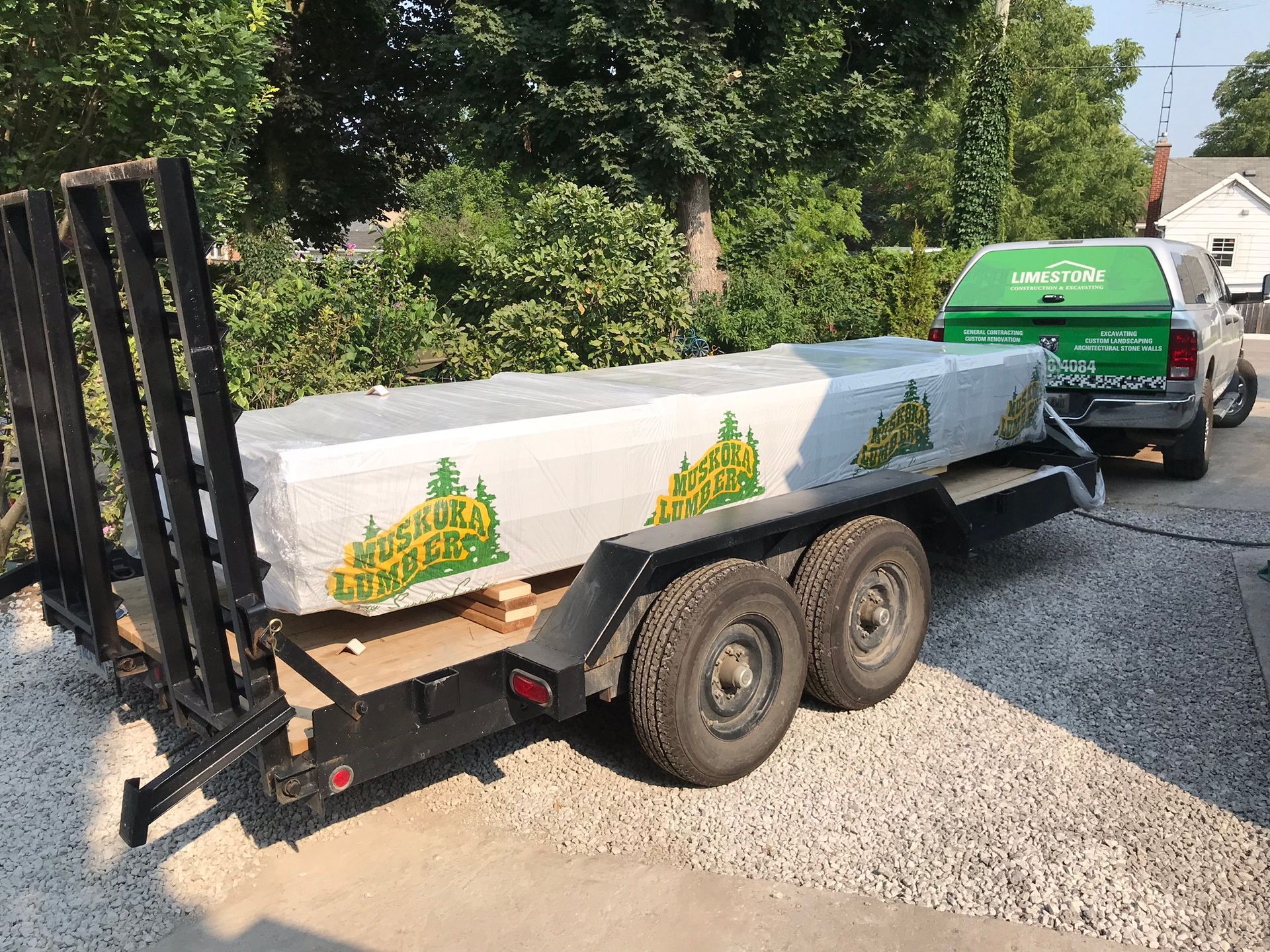 a truck is pulling a trailer with lumber on it .