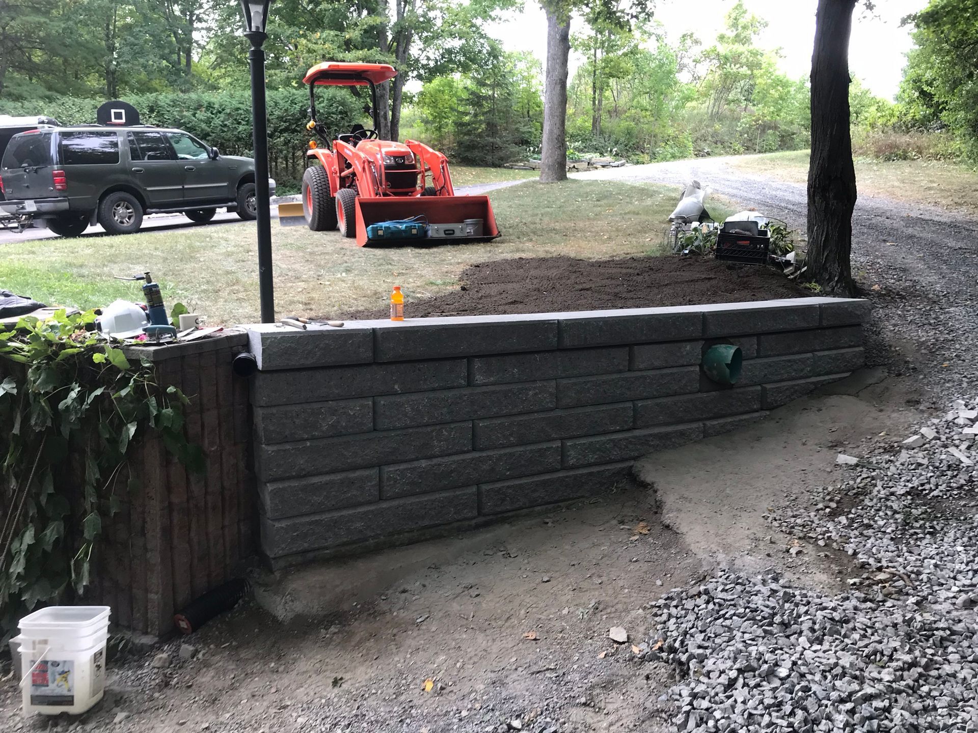 a tractor is parked next to a brick wall in a yard .