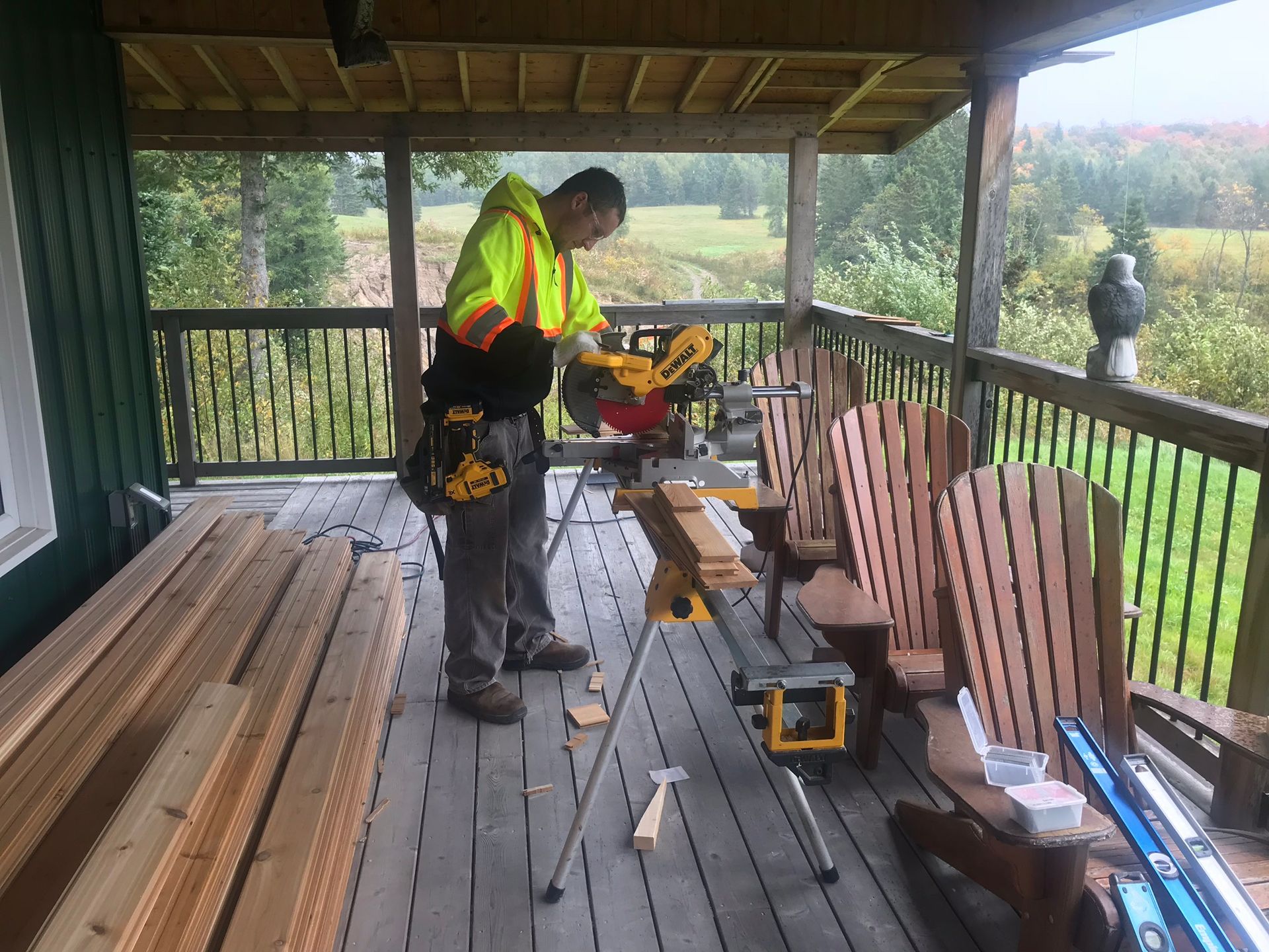 a man is cutting wood on a porch with a circular saw