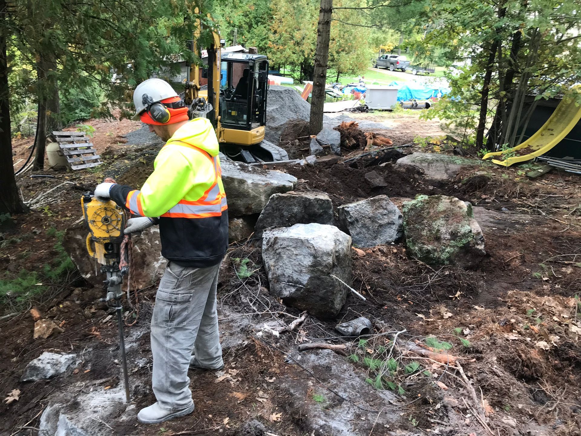 a man is using a hammer to break rocks in the dirt .